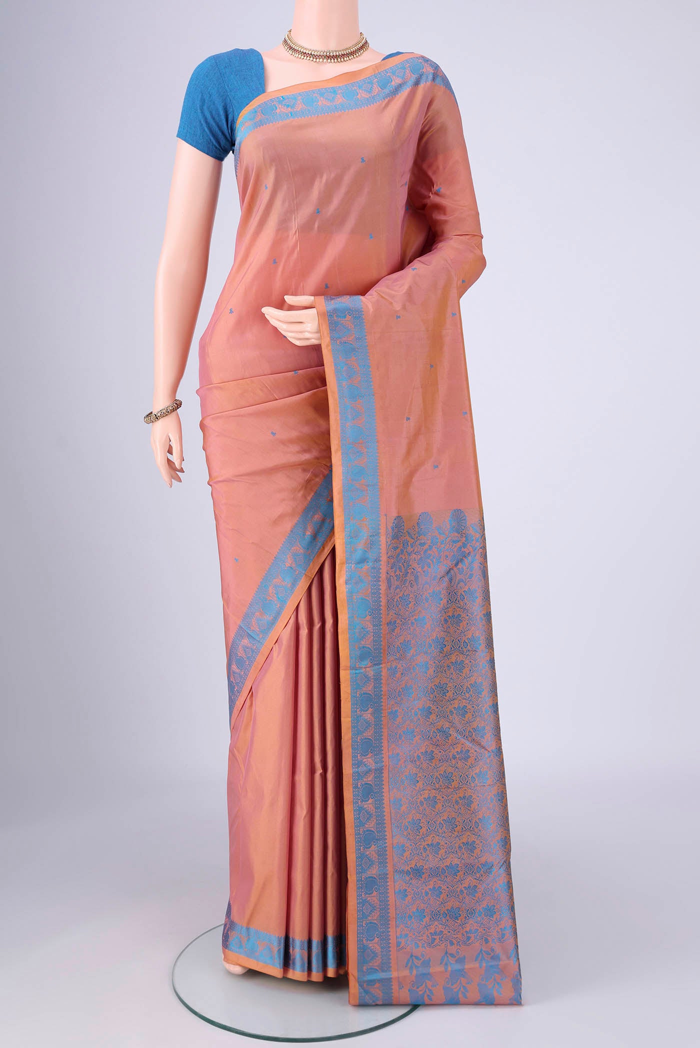 Peach Kanchipuram Silk Saree with Thread Butta on the body and Thread Border.  displayed on a mannequin
