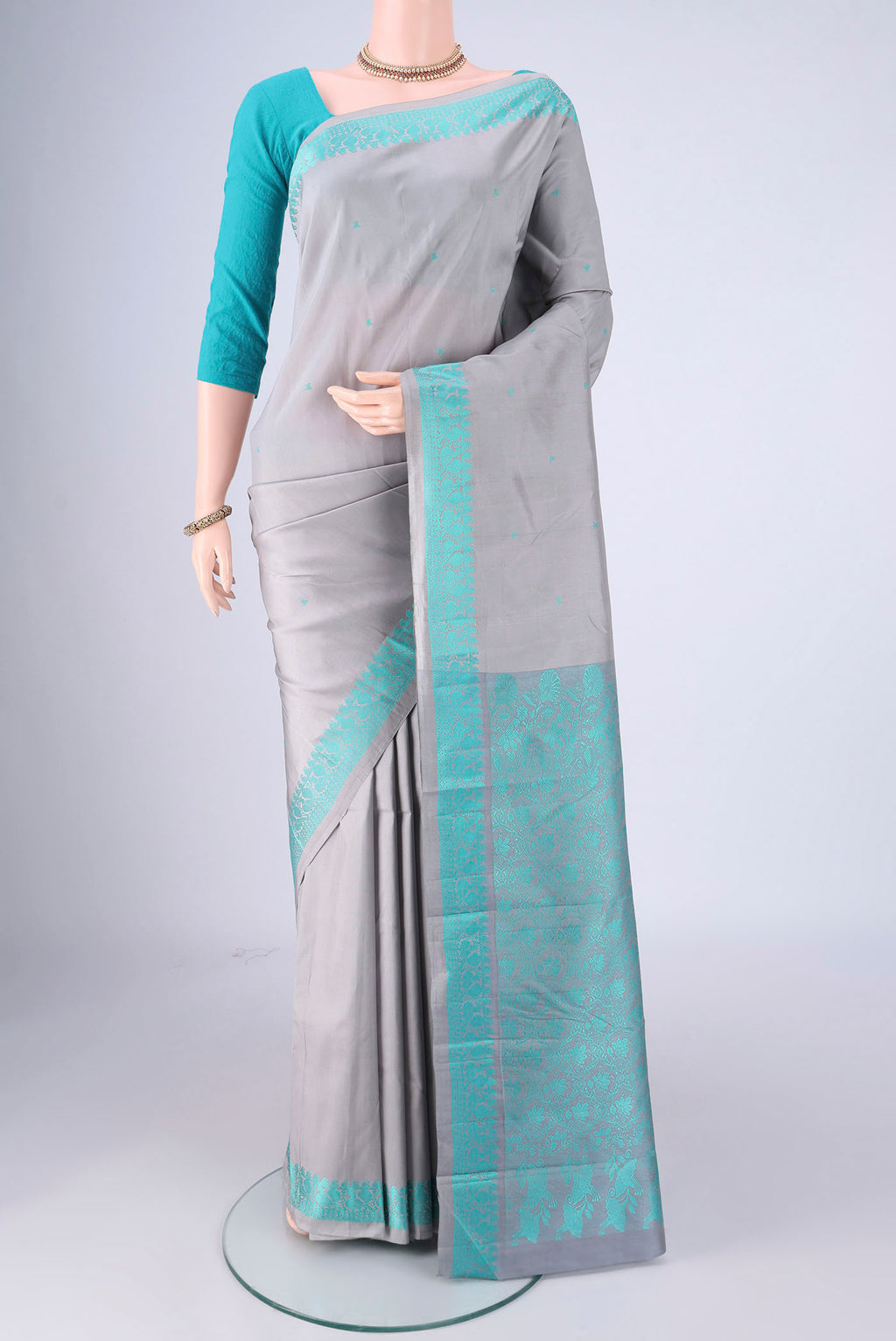 Grey Kanchipuram Silk Saree with Thread Butta on the body and Thread Border.  displayed on a mannequin