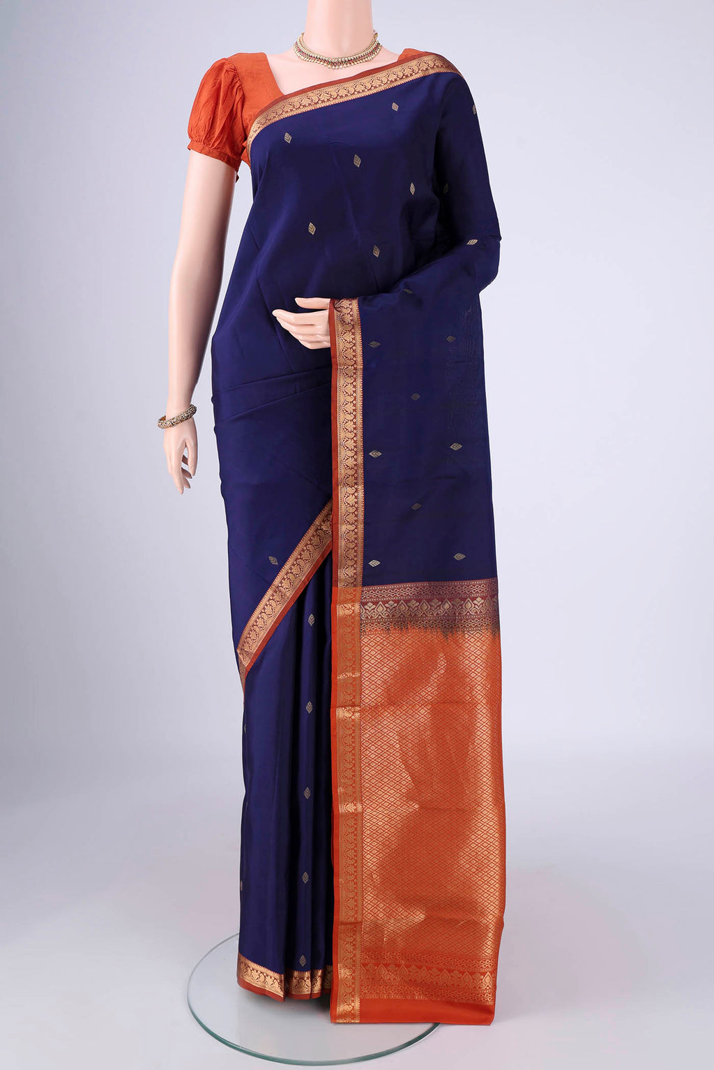 Navy Blue Kanchipuram Silk Saree with Zari Butta on the body and Zari Border.  displayed on a mannequin