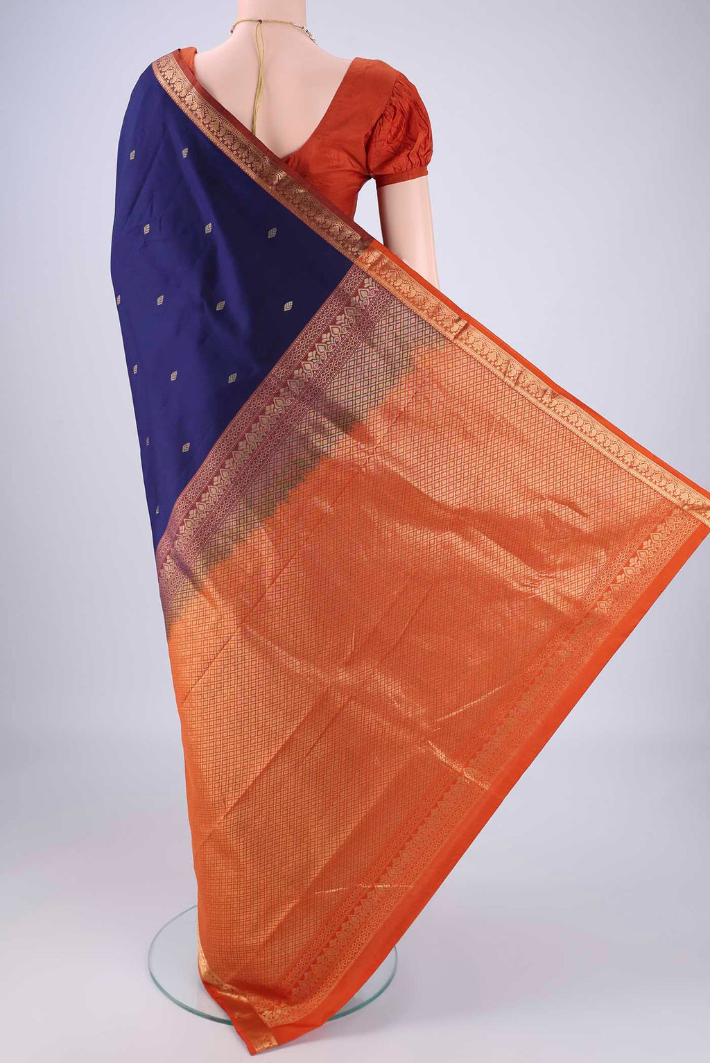Flat view of Navy Blue Kanchipuram Silk Saree with Zari Butta on the body and Zari Border. 