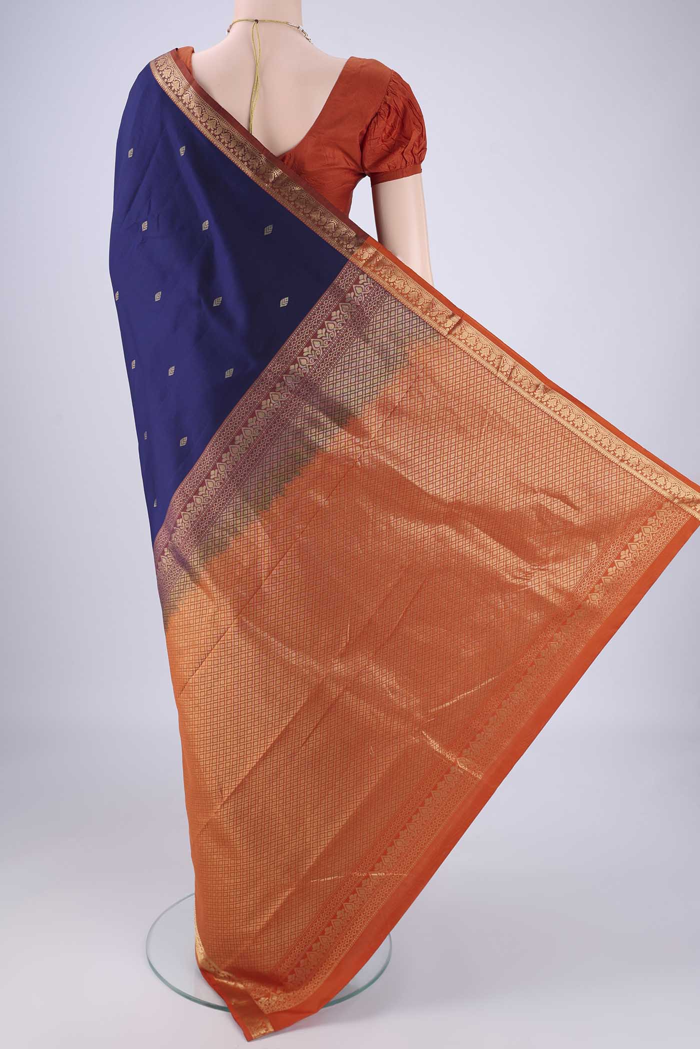 Flat view of Navy Blue Kanchipuram Silk Saree with Zari Butta on the body and Zari Border. 