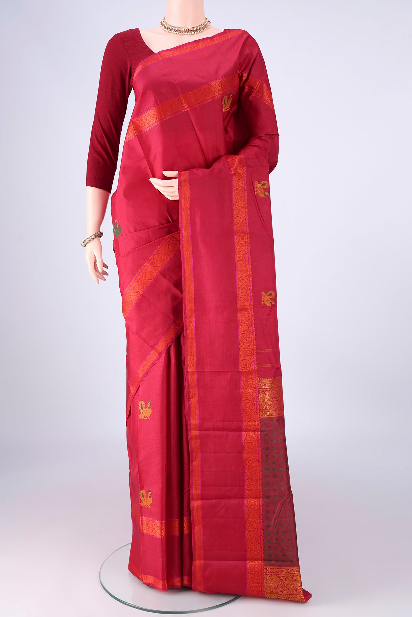 Maroon Kanchipuram Silk Saree with Thread Butta on the body and Thread Border.  displayed on a mannequin