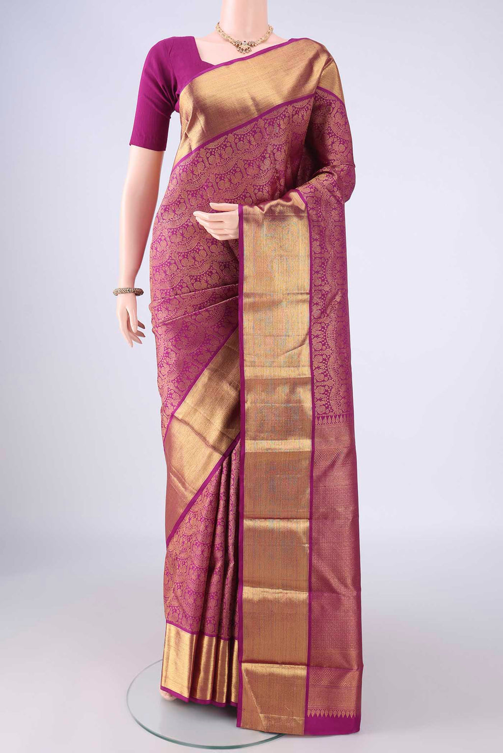 Magenta Kanchipuram Silk Saree with Zari Brocade on the body and Zari Border.  displayed on a mannequin