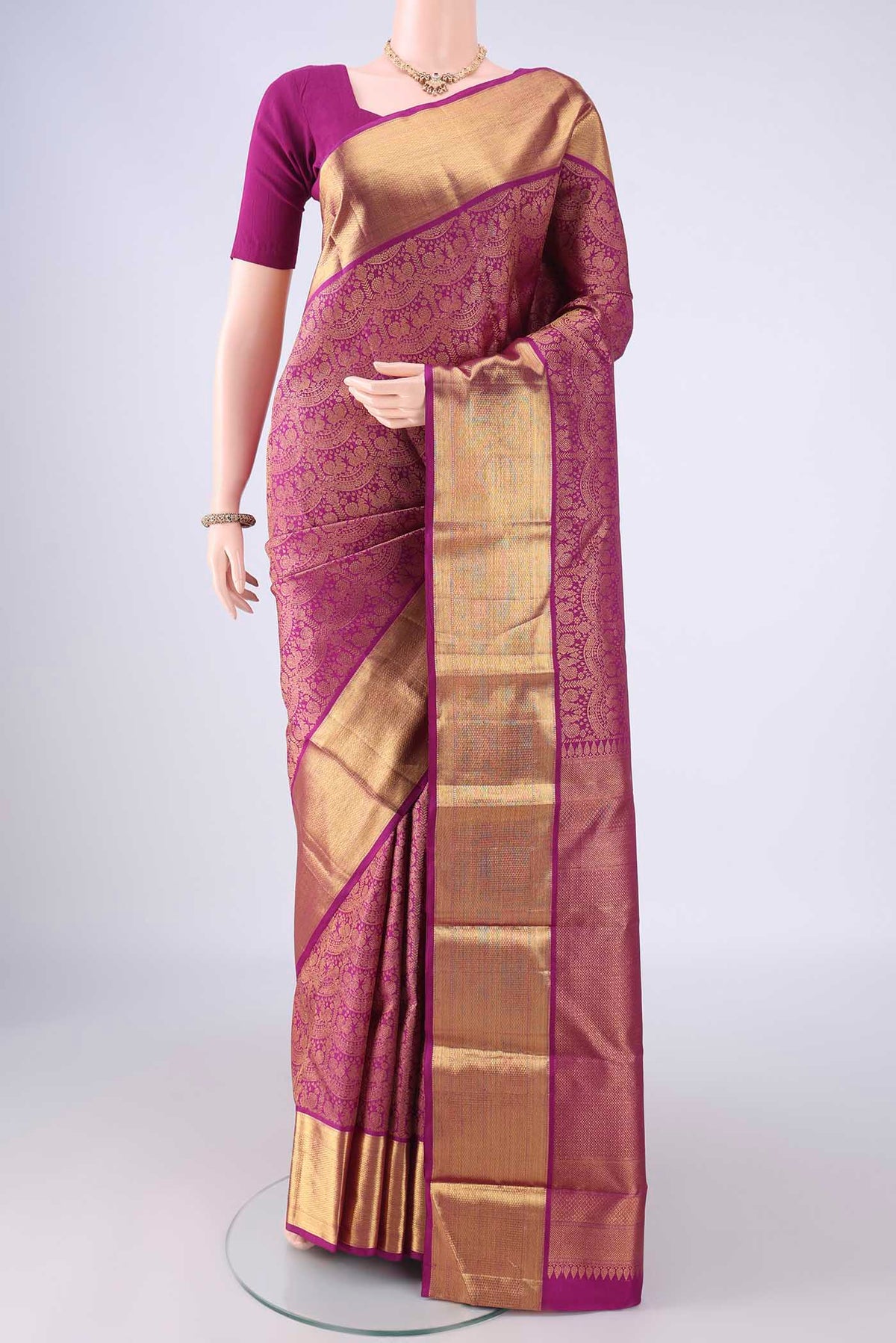 Magenta Kanchipuram Silk Saree with Zari Brocade on the body and Zari Border.  displayed on a mannequin