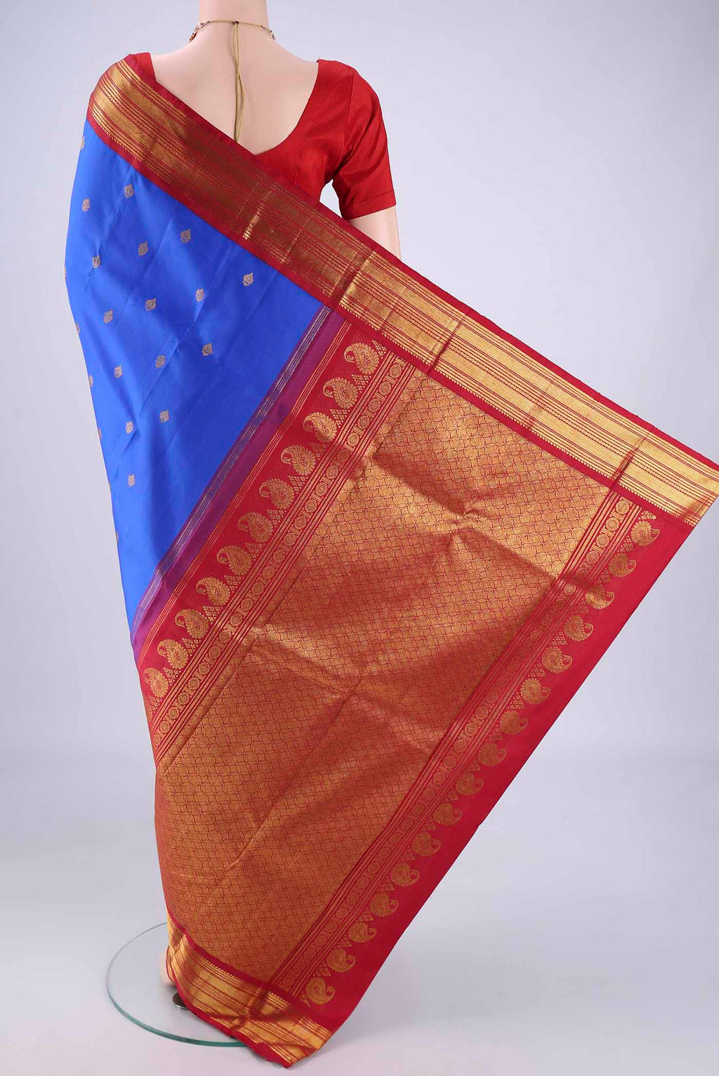 Flat view of Royal Blue Kanchipuram Silk Saree with Zari Butta on the body and Zari Border. 