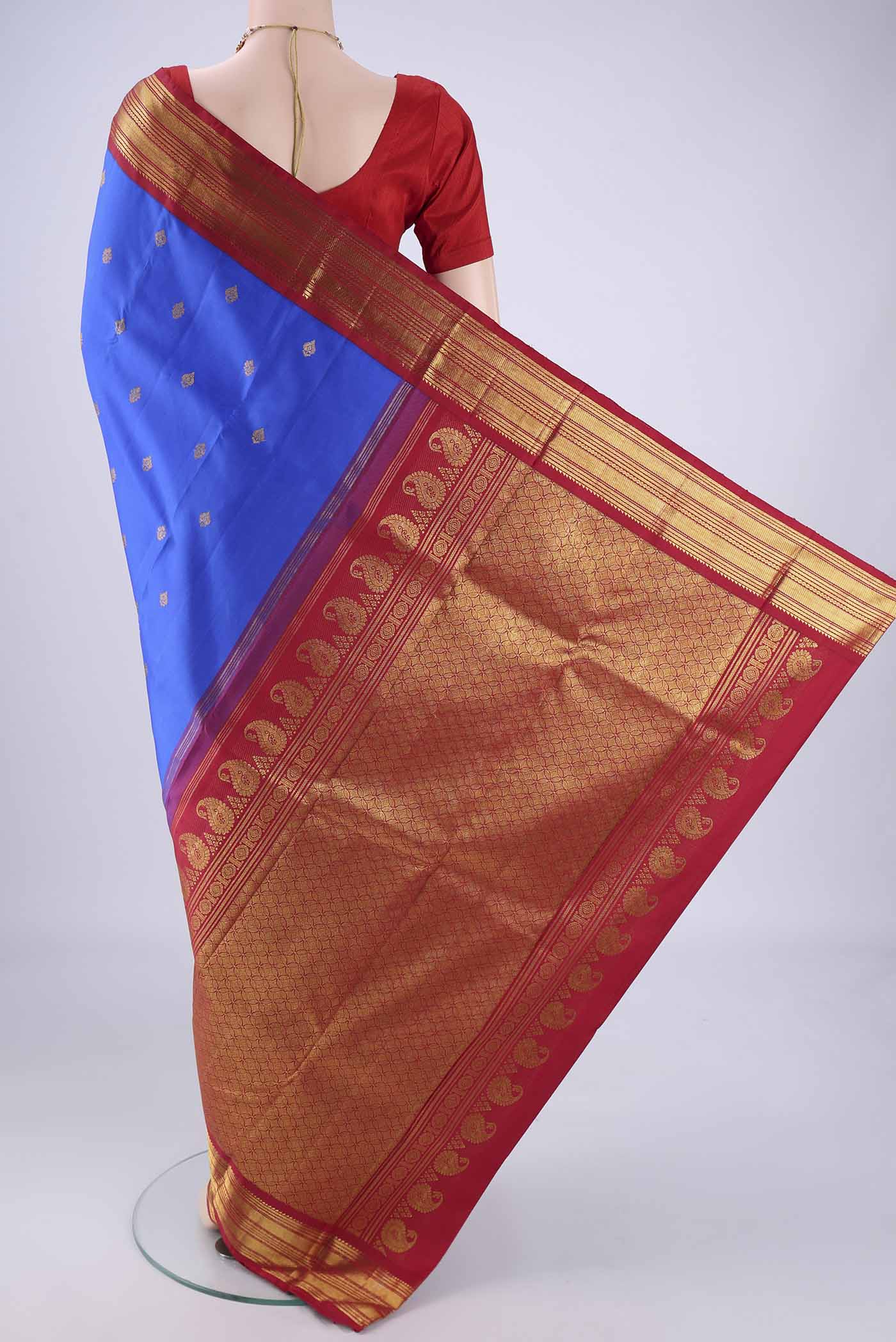 Flat view of Royal Blue Kanchipuram Silk Saree with Zari Butta on the body and Zari Border. 