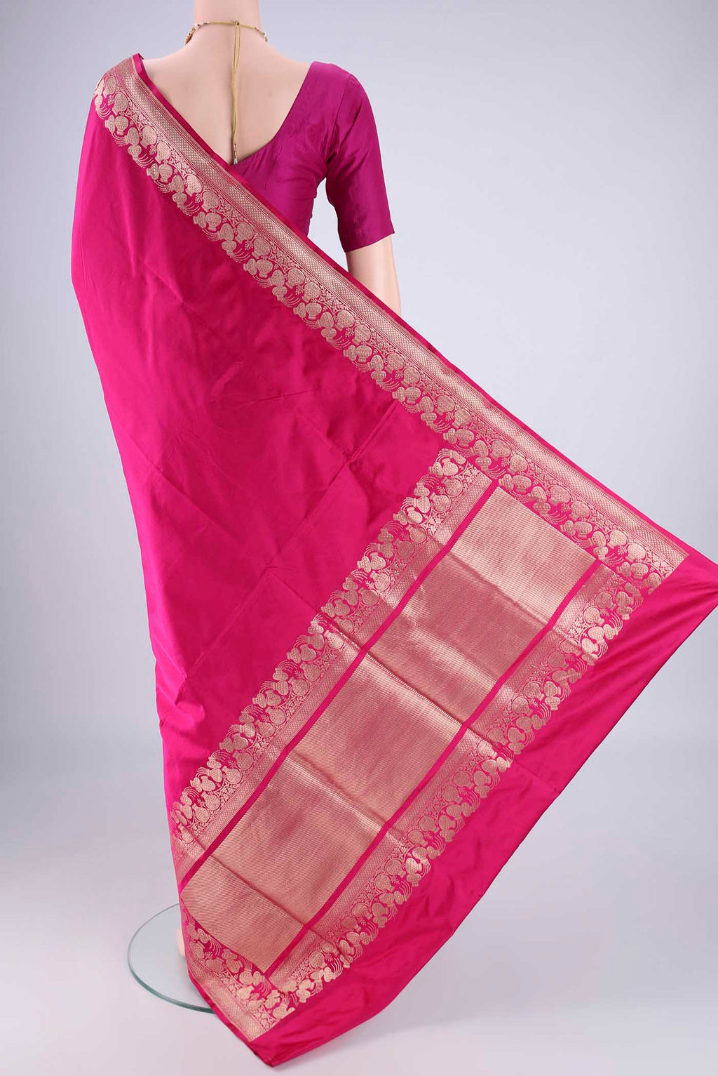 Flat view of Rani Pink Banarasi Silk Saree with Plain Body and Zari Border. 