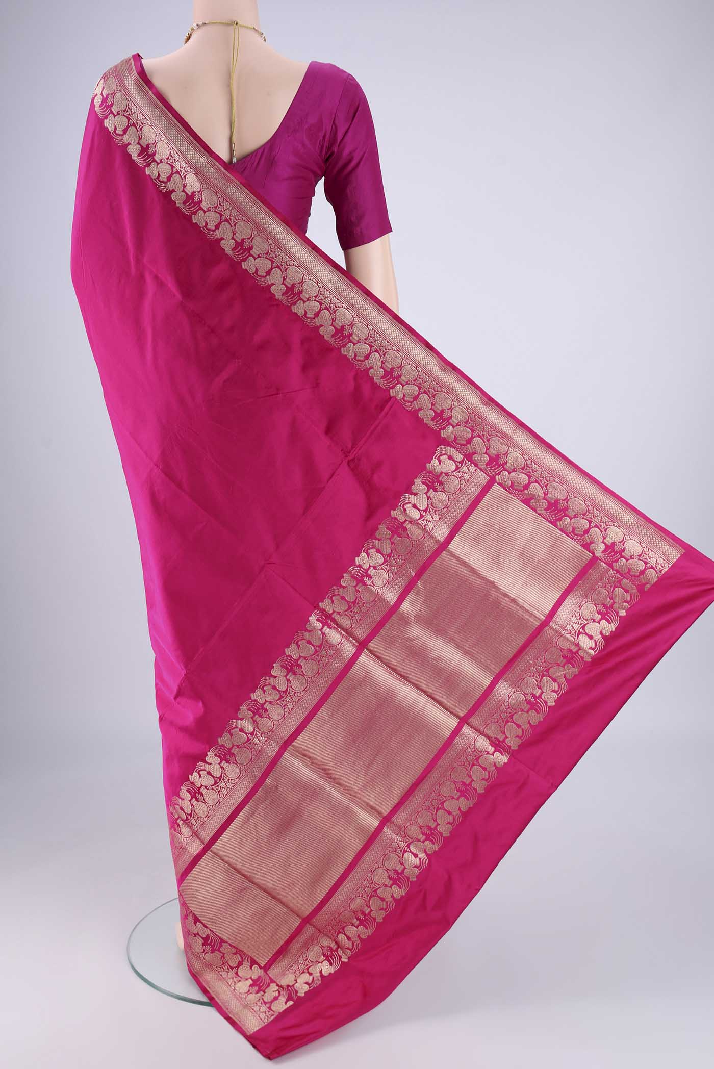 Flat view of Rani Pink Banarasi Silk Saree with Plain Body and Zari Border. 
