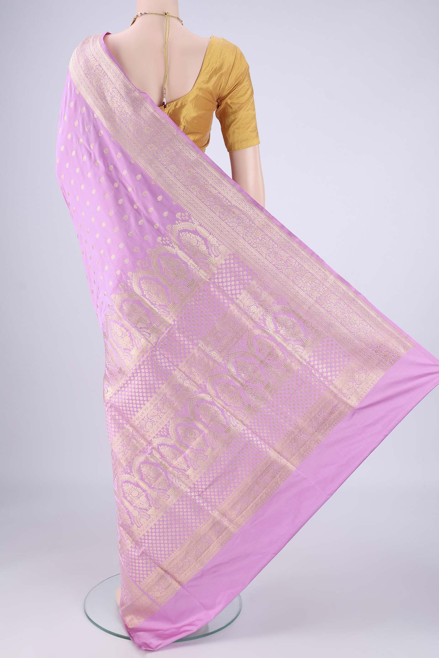 Flat view of Lilac Banarasi Silk Saree with Zari Butta on the body and Zari Border. 