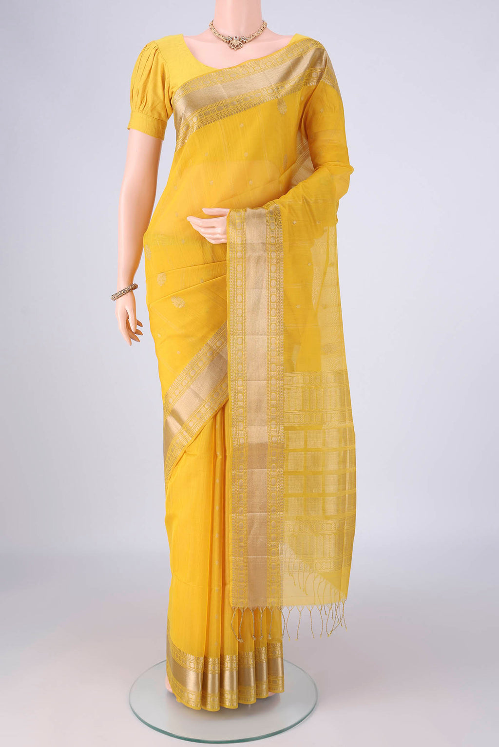 Yellow Kora Cotton Saree with Zari Butta on the body and Zari Border.  displayed on a mannequin