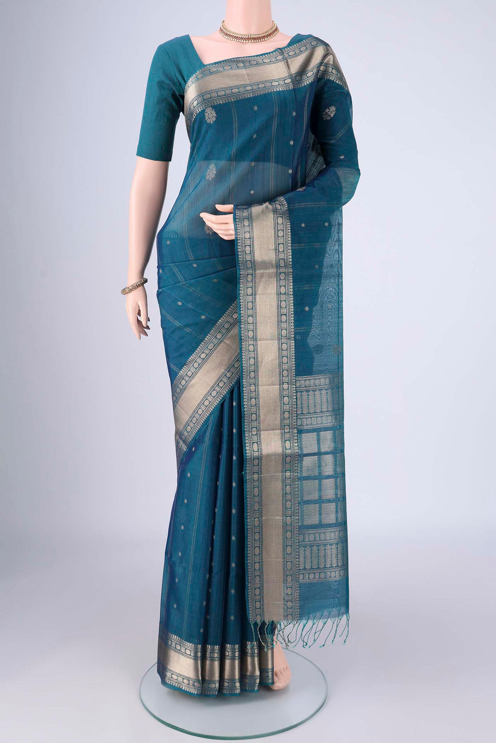 Peacock Blue Silk Cotton Saree with Zari Butta on the body and Zari Border.  displayed on a mannequin