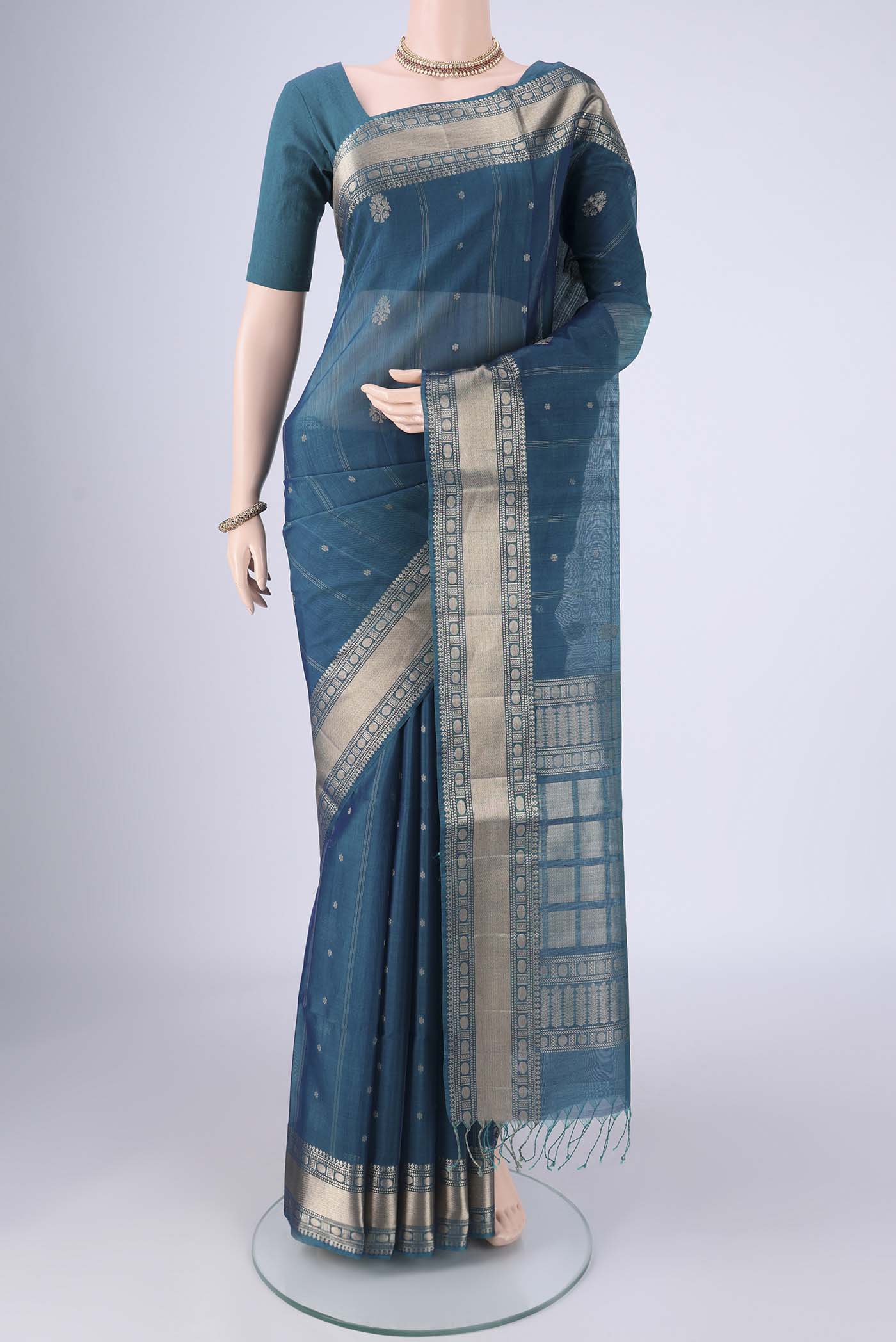 Peacock Blue Silk Cotton Saree with Zari Butta on the body and Zari Border.  displayed on a mannequin