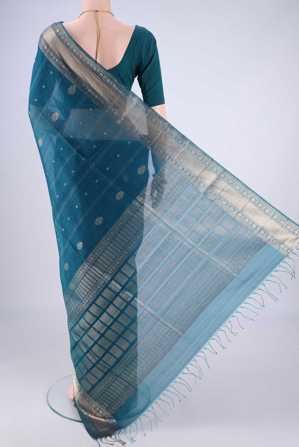 Flat view of Peacock Blue Silk Cotton Saree with Zari Butta on the body and Zari Border. 