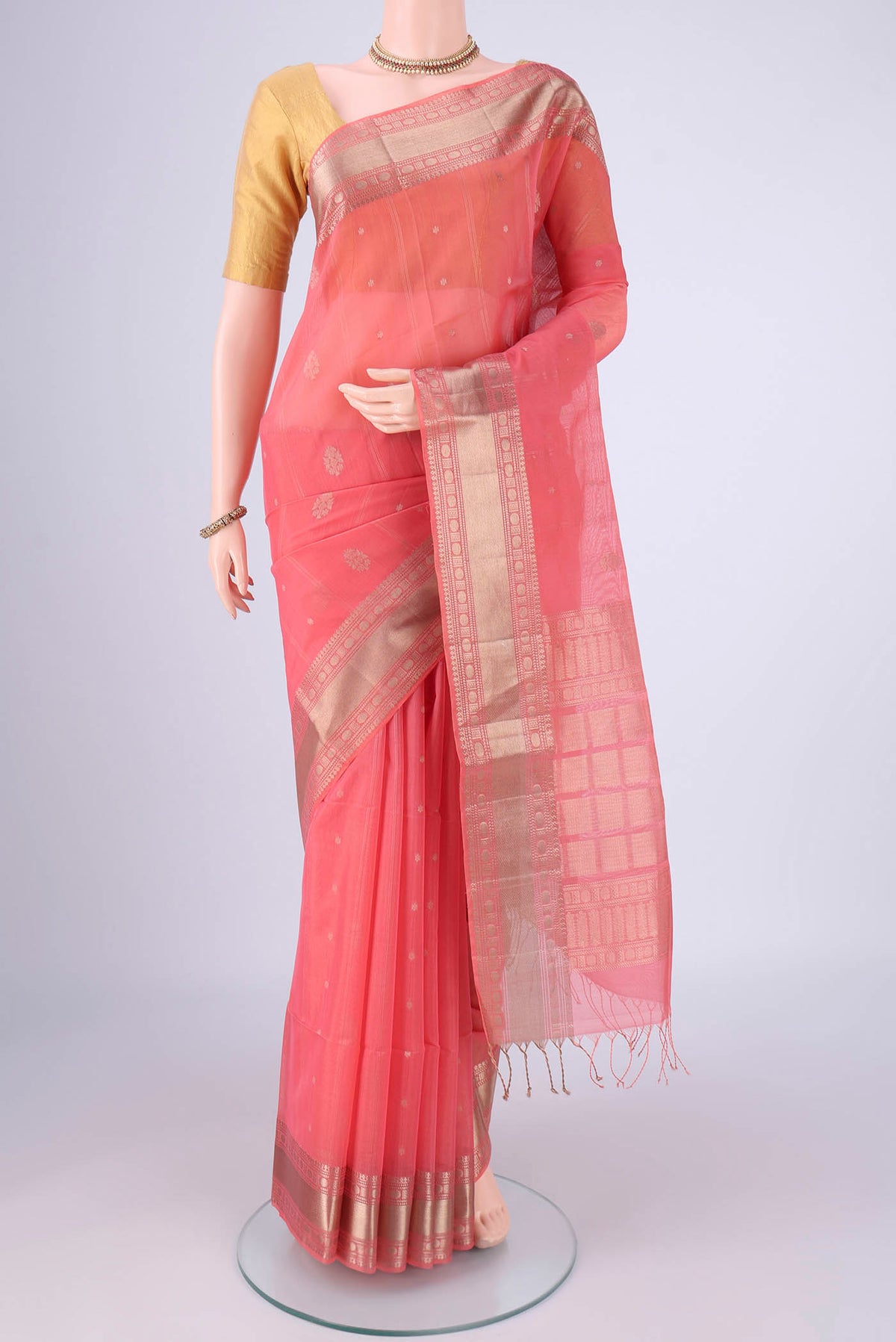 Peach Silk Cotton Saree with Zari Butta on the body and Zari Border.  displayed on a mannequin