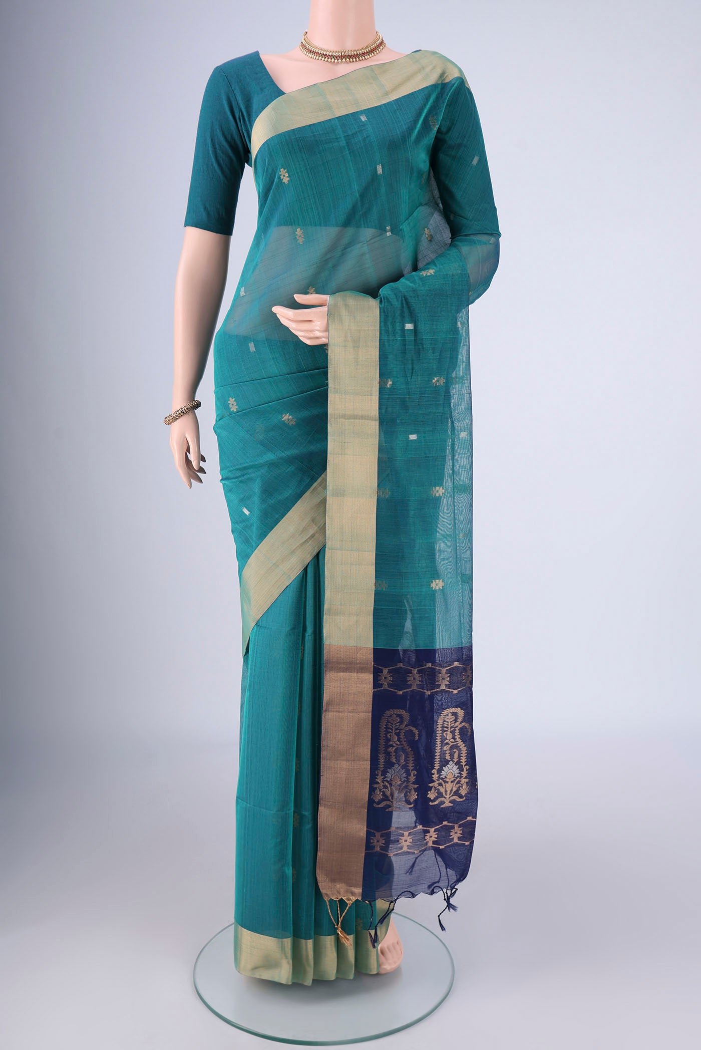 Sea Green Silk Cotton Saree with Zari Butta on the body and Zari Border.  displayed on a mannequin