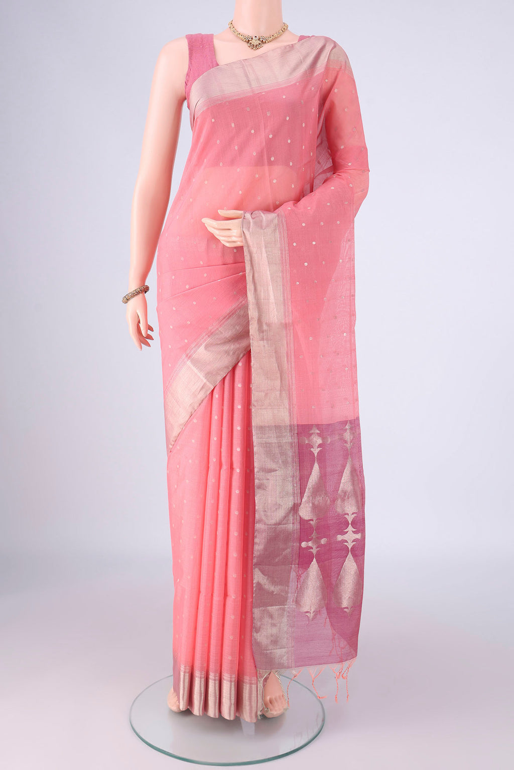 Peach Kora Cotton Saree with Zari Butta on the body and Zari Border.  displayed on a mannequin