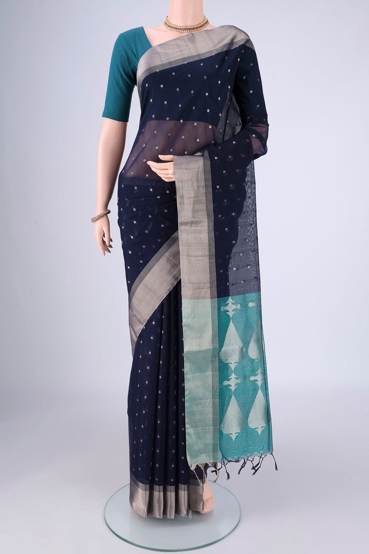 Navy Blue Silk Cotton Saree with Zari Butta on the body and Zari Border.  displayed on a mannequin