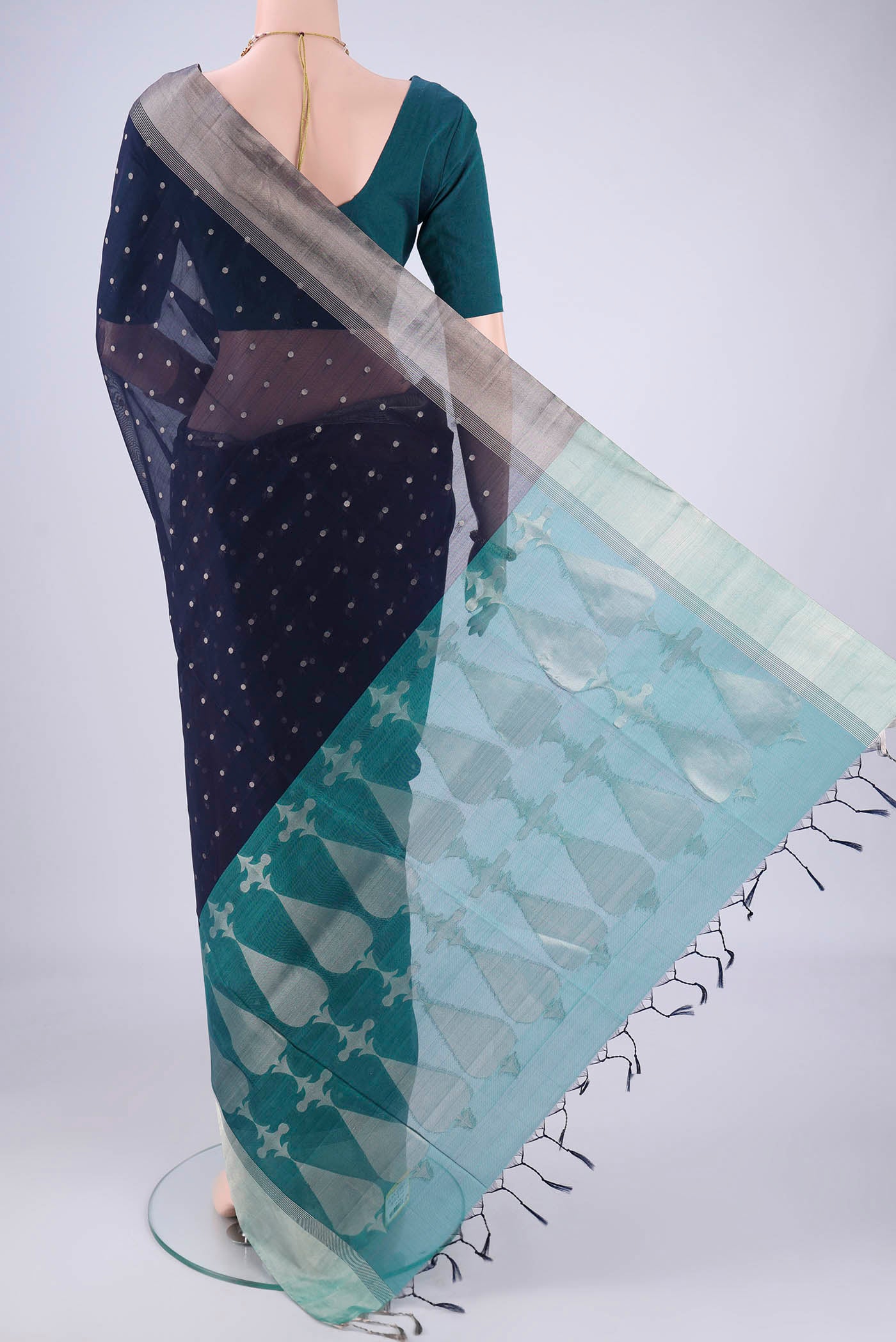 Flat view of Navy Blue Silk Cotton Saree with Zari Butta on the body and Zari Border. 