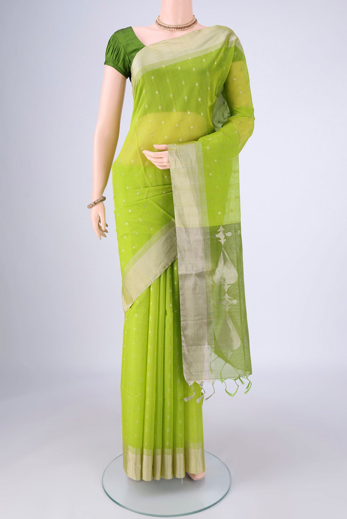 Parrot Green Silk Cotton Saree with Zari Butta on the body and Zari Border.  displayed on a mannequin