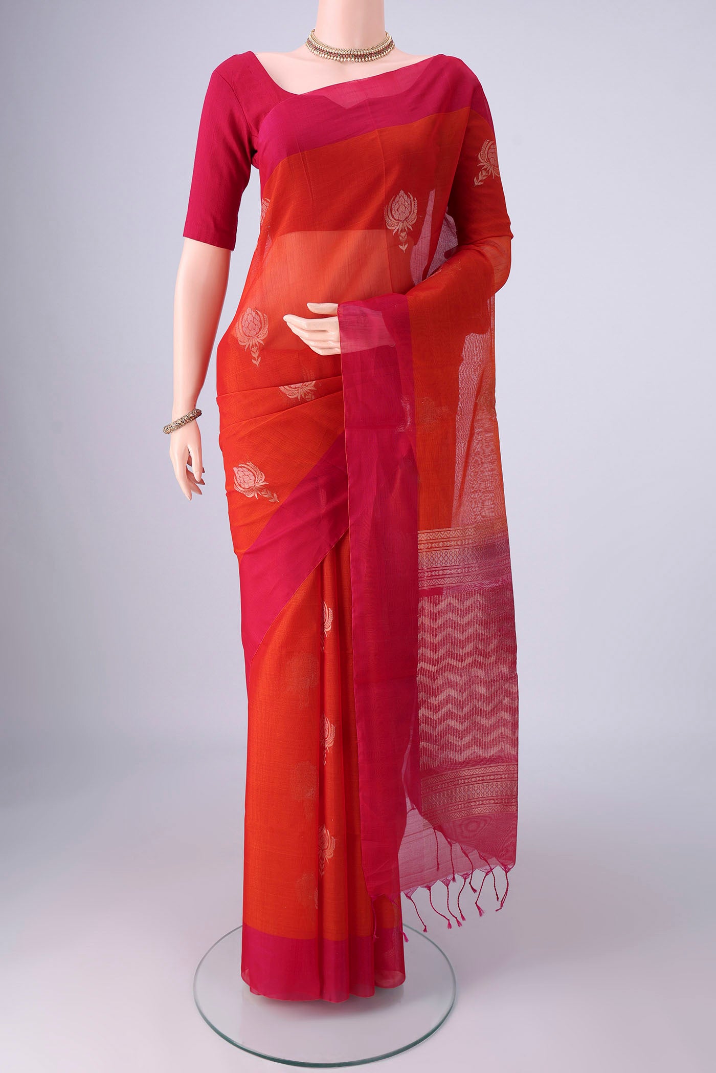 Rust Kora Cotton Saree with Zari Butta on the body and Plain Border.  displayed on a mannequin