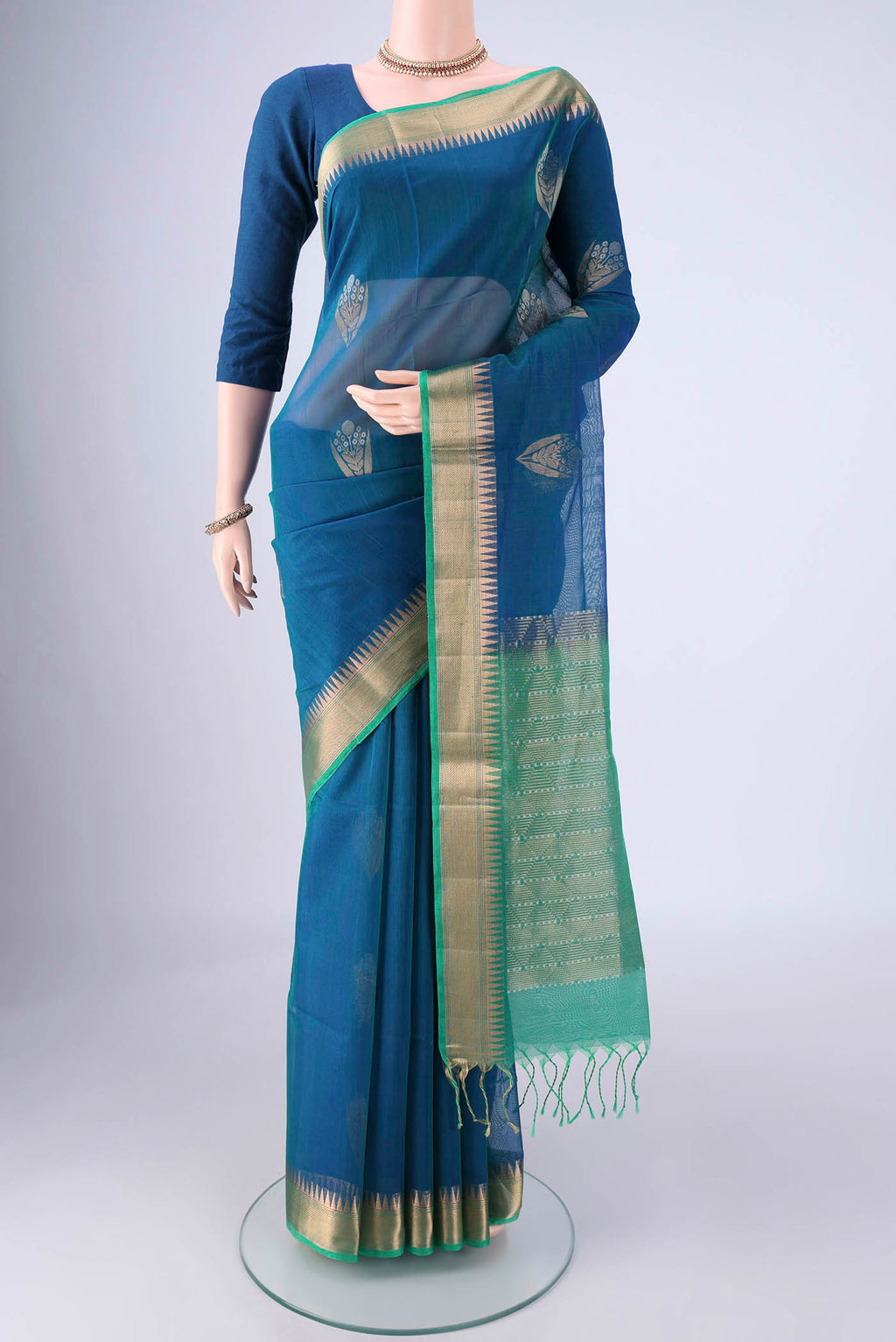 Peacock Blue Silk Cotton Saree with Zari Butta on the body and Zari Border.  displayed on a mannequin
