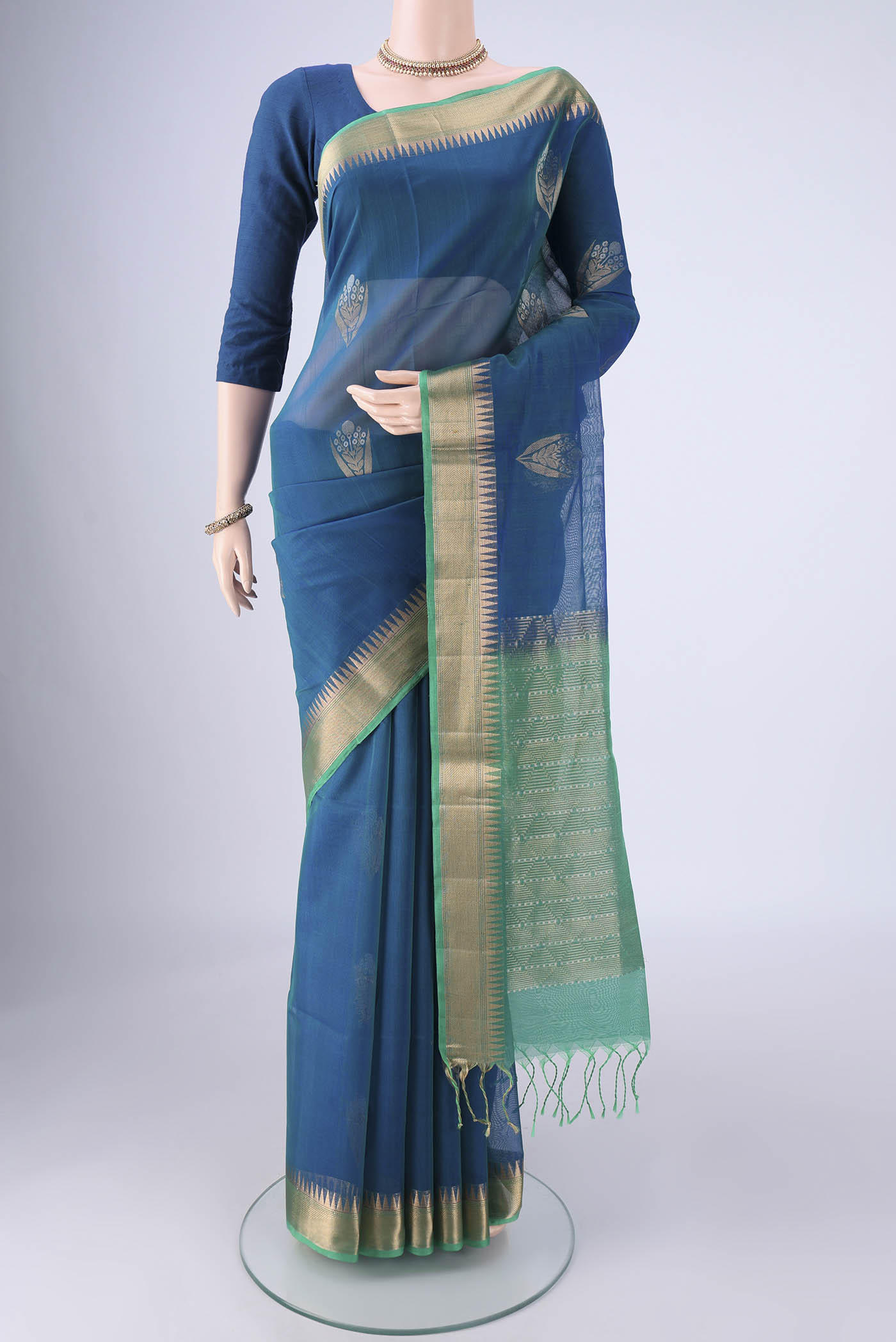 Peacock Blue Silk Cotton Saree with Zari Butta on the body and Zari Border.  displayed on a mannequin