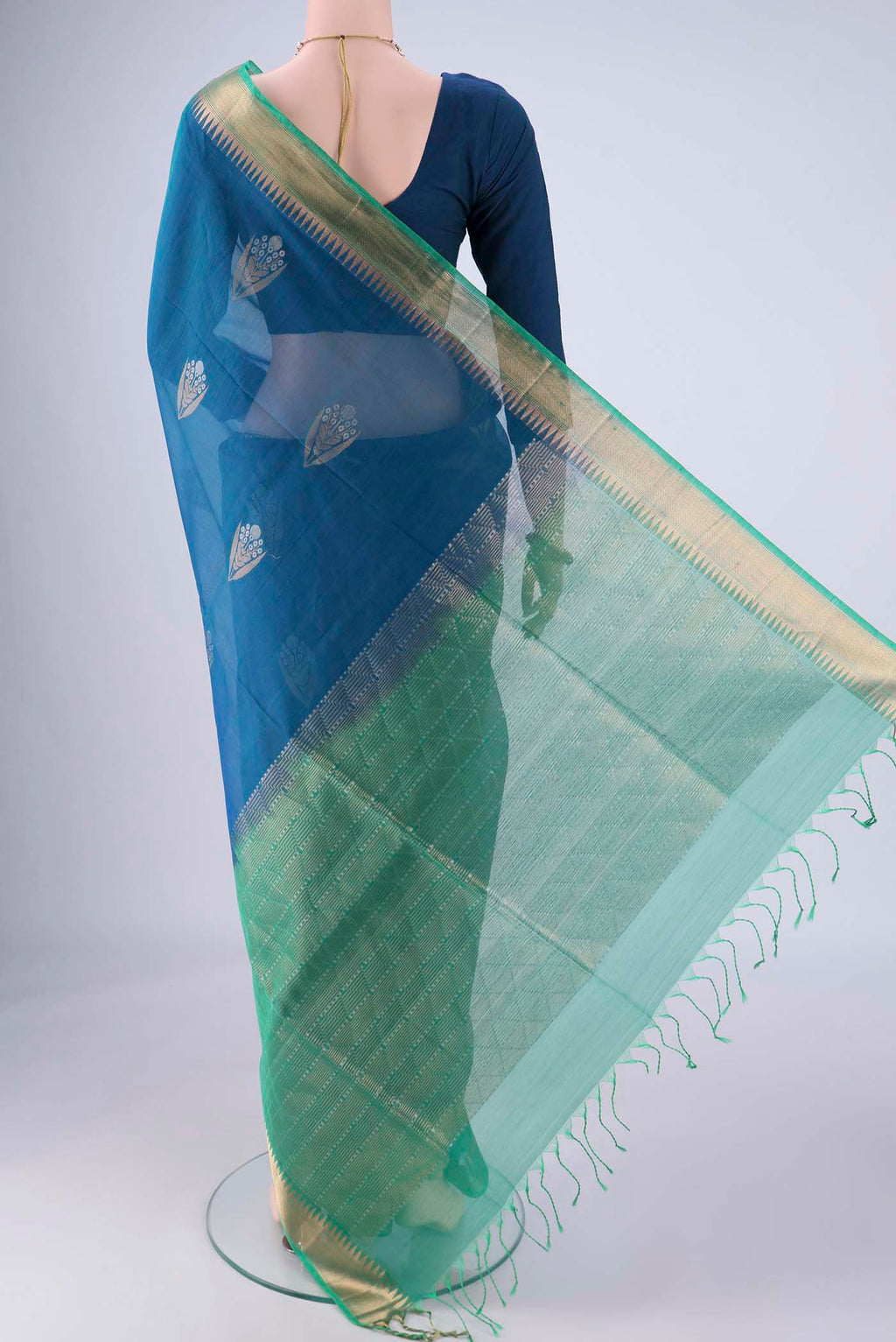 Flat view of Peacock Blue Silk Cotton Saree with Zari Butta on the body and Zari Border. 