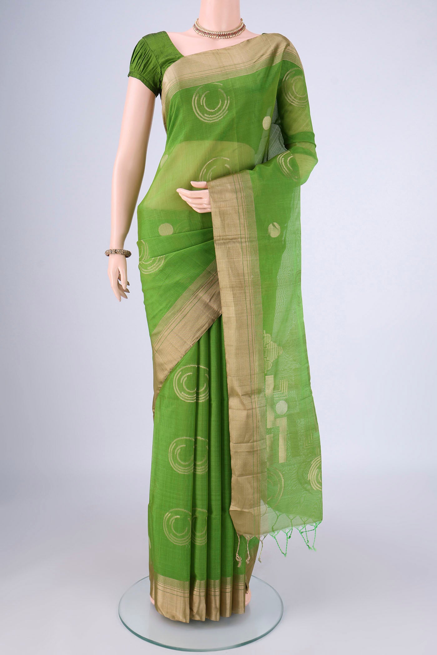 Green Silk Cotton Saree with Zari Butta on the body and Zari Border.  displayed on a mannequin