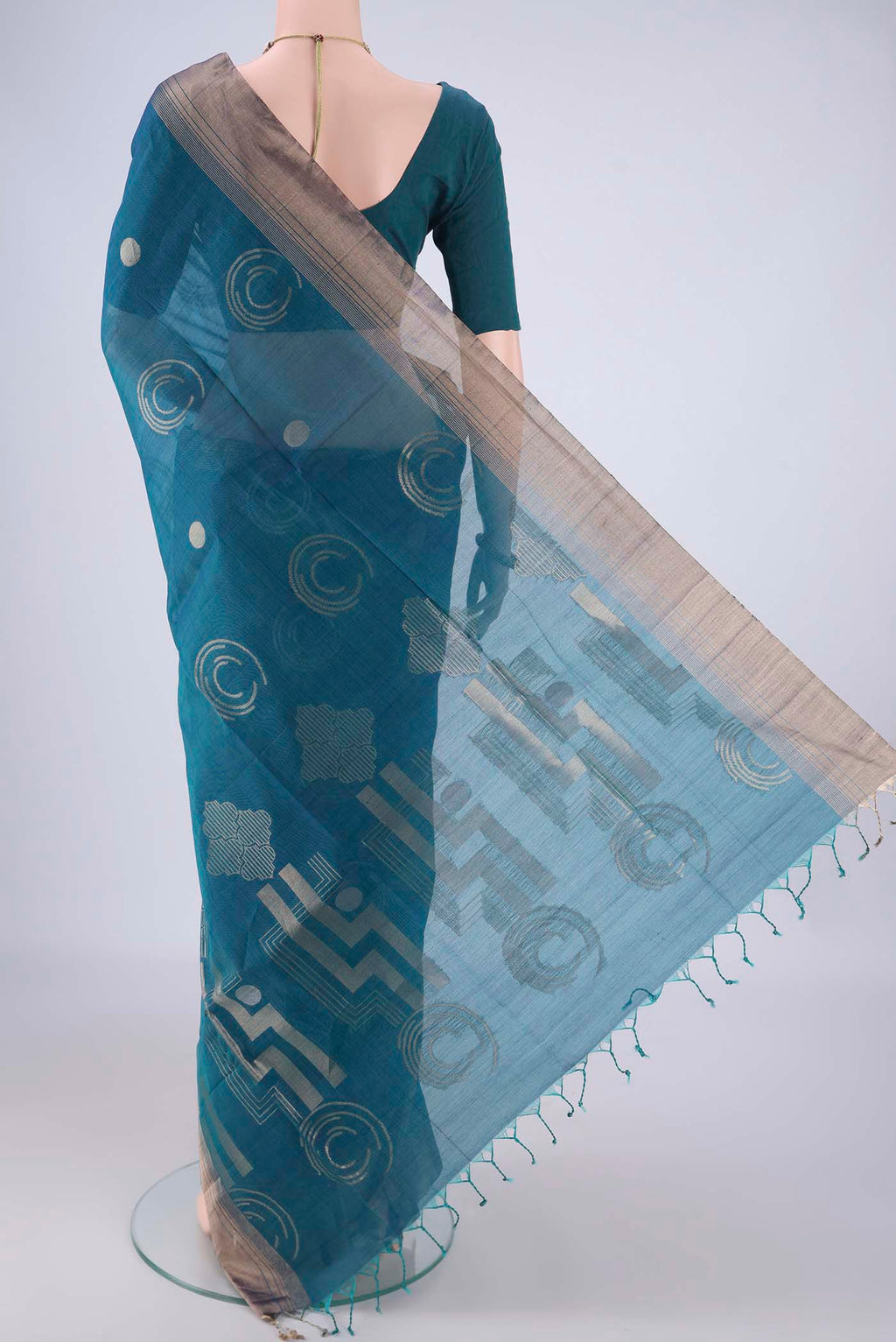 Flat view of Peacock Blue Kora Cotton Saree with Zari Butta on the body and Zari Border. 
