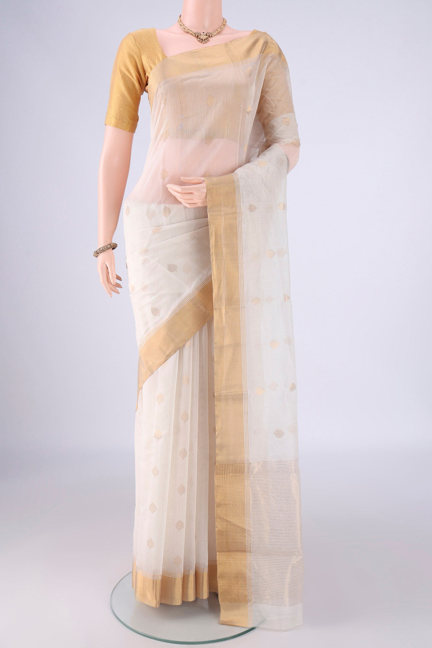 Off White Chanderi Silk Cotton Saree with Zari Butta on the body and Zari Border.  displayed on a mannequin