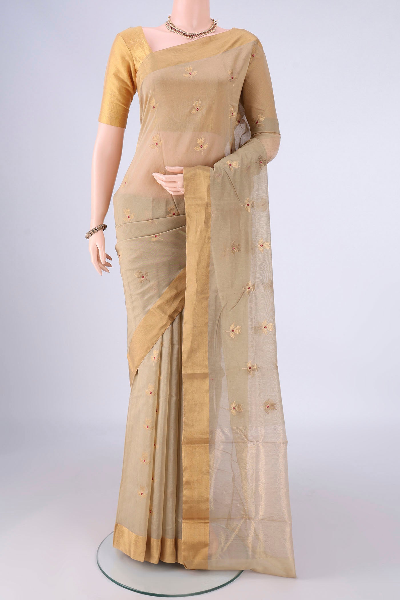Beige Chanderi Silk Cotton Saree with Zari And Thread Butta on the body and Zari Border.  displayed on a mannequin