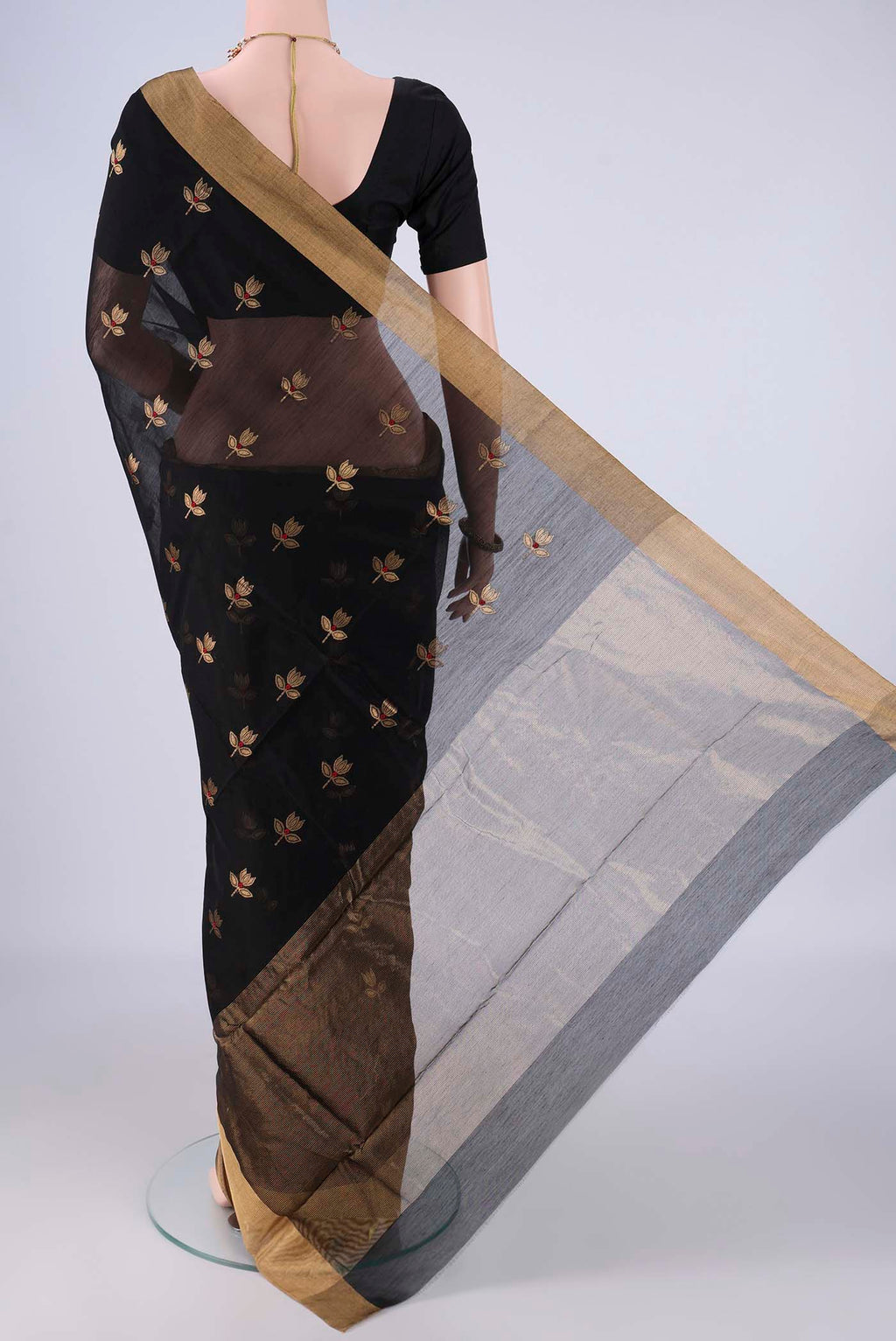 Flat view of Black Silk Cotton Saree with Zari And Thread Butta on the body and Zari Border. 