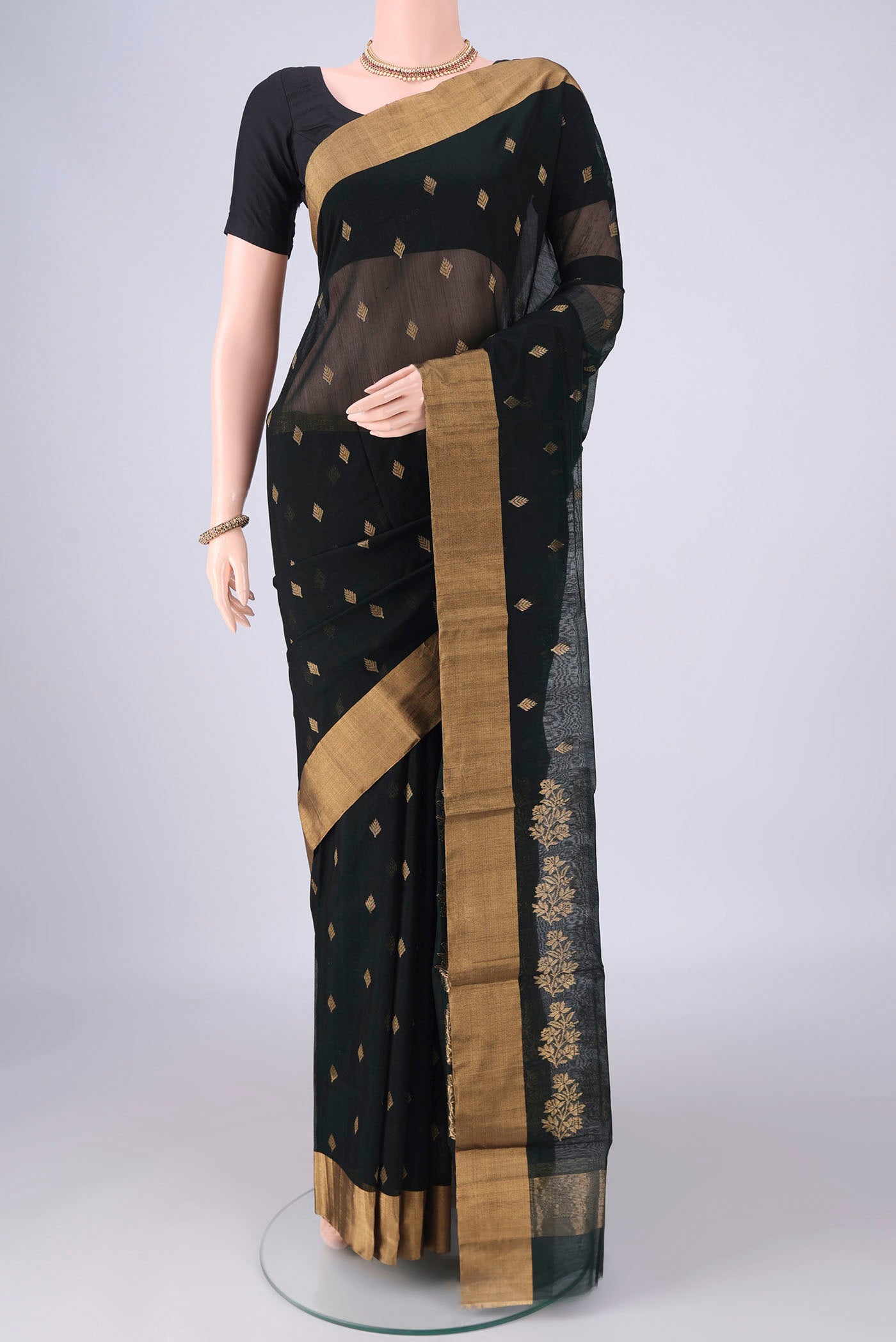 Bottle Green Chanderi Silk Cotton Saree with Zari Butta on the body and Zari Border.  displayed on a mannequin