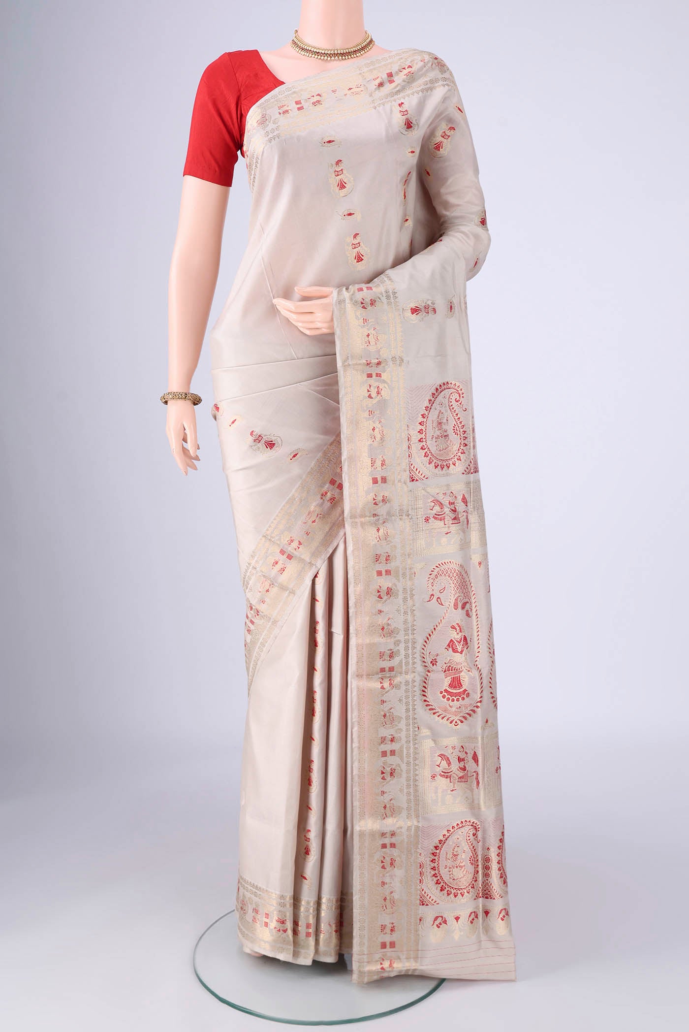 Beige Baluchari Silk Saree with Zari And Thread Butta on the body and Zari And Thread Border.  displayed on a mannequin