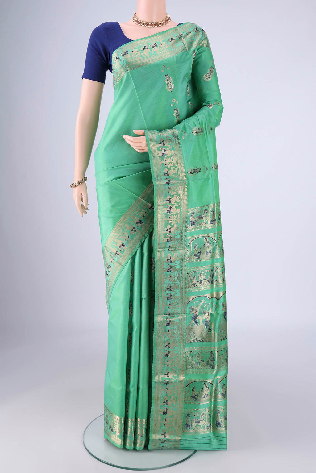 Sea Green Baluchari Silk Saree with Zari And Thread Butta on the body and Zari And Thread Border.  displayed on a mannequin