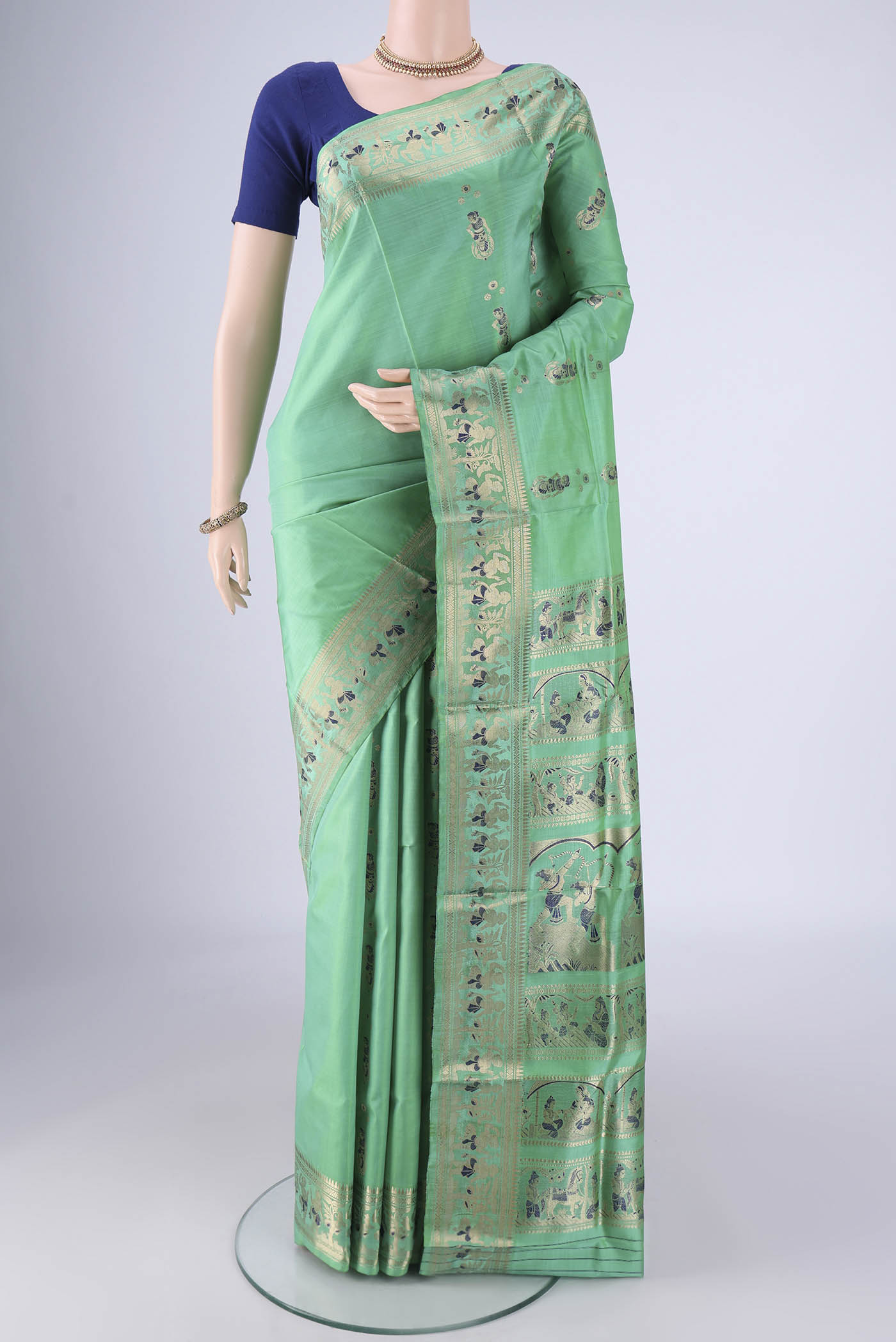 Sea Green Baluchari Silk Saree with Zari And Thread Butta on the body and Zari And Thread Border.  displayed on a mannequin