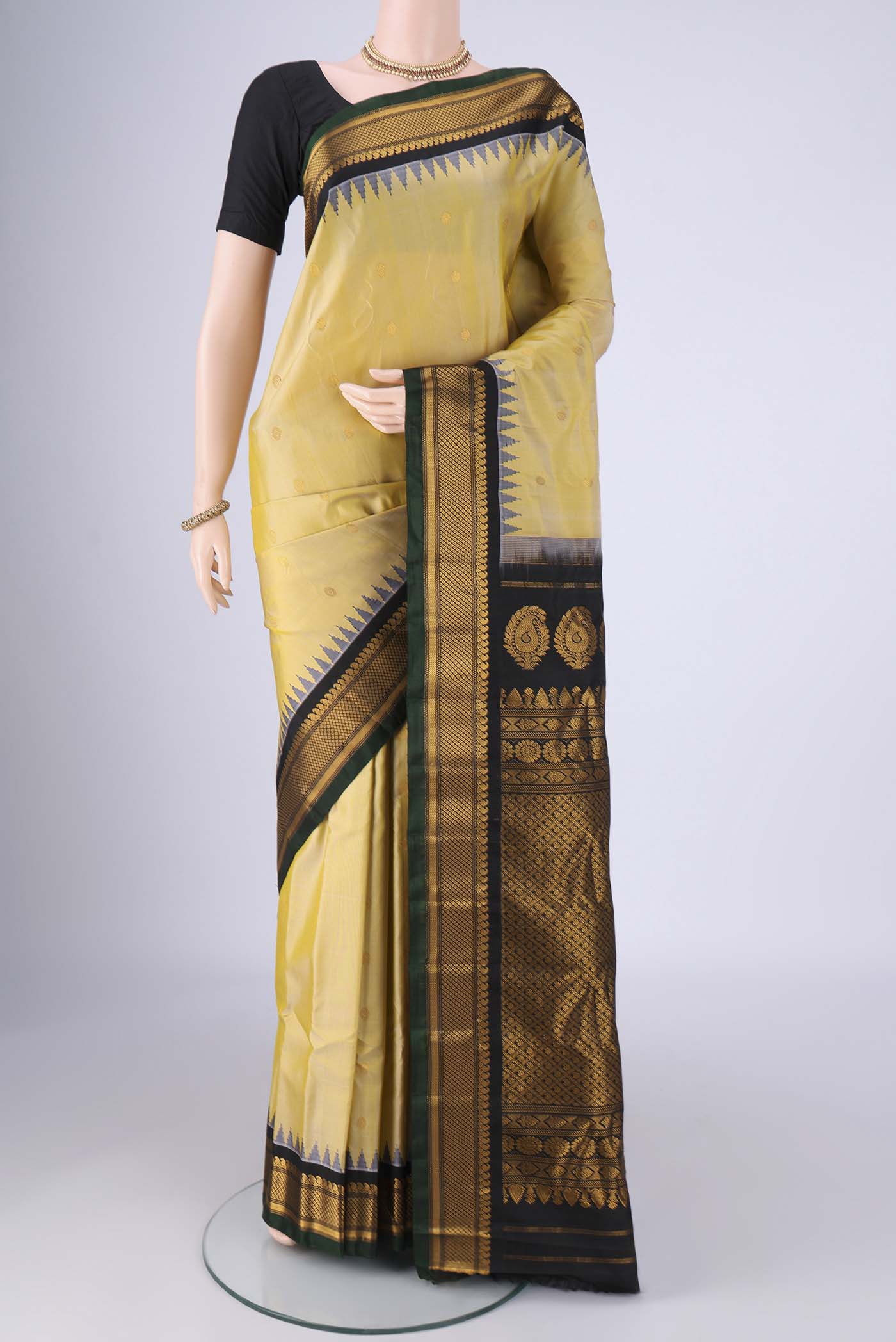 Lemon Yellow Gadwal Silk Saree with Zari Butta on the body and Zari Border.  displayed on a mannequin