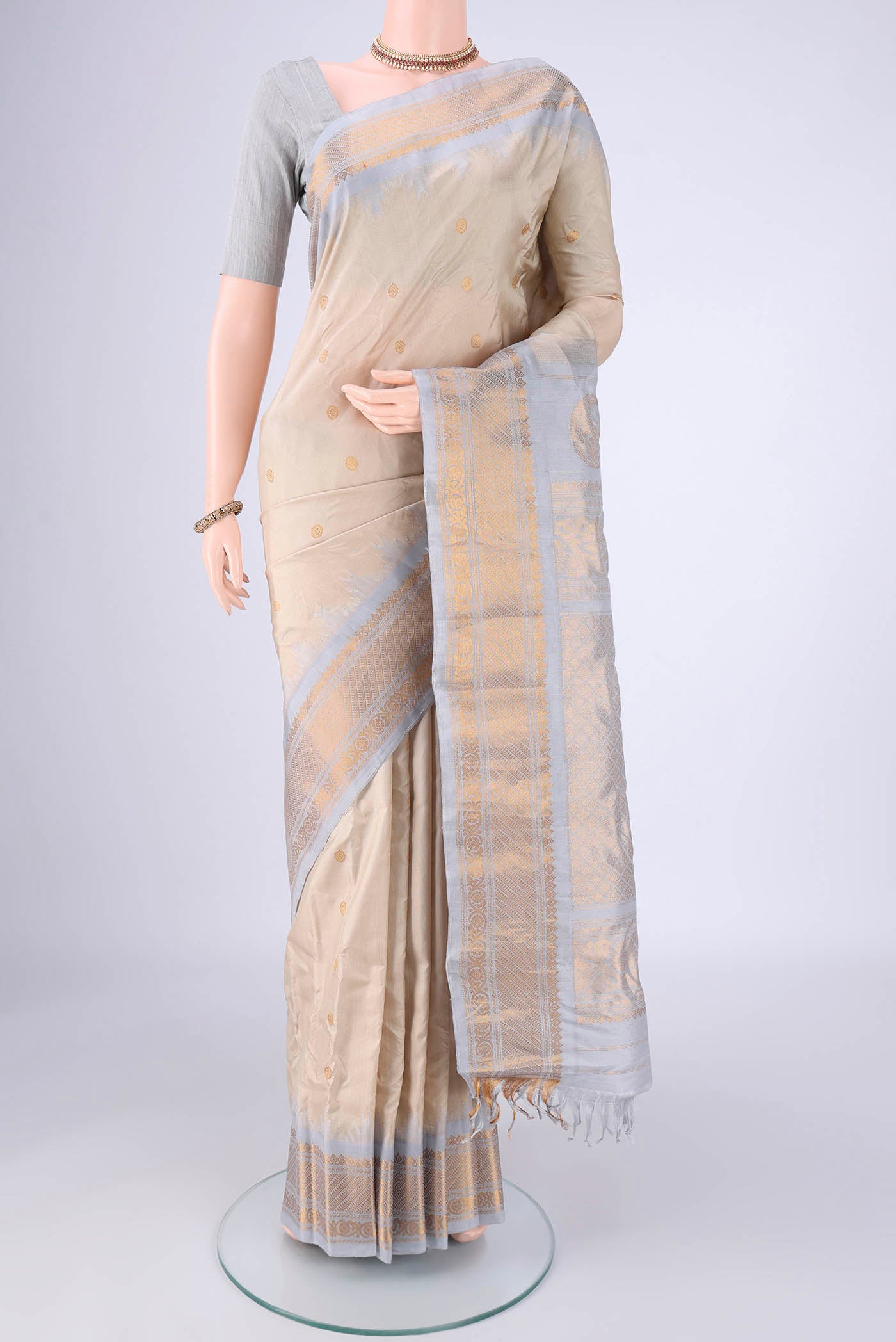 Beige Gadwal Silk Saree with Zari Butta on the body and Zari Border.  displayed on a mannequin
