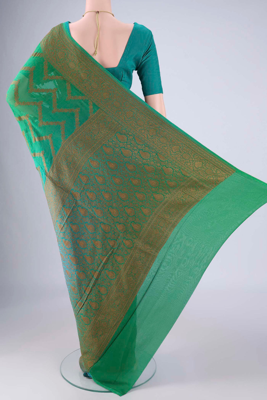 Flat view of Green Banarasi Georgette Saree with Zig Zag design on the body and Zari Border. 