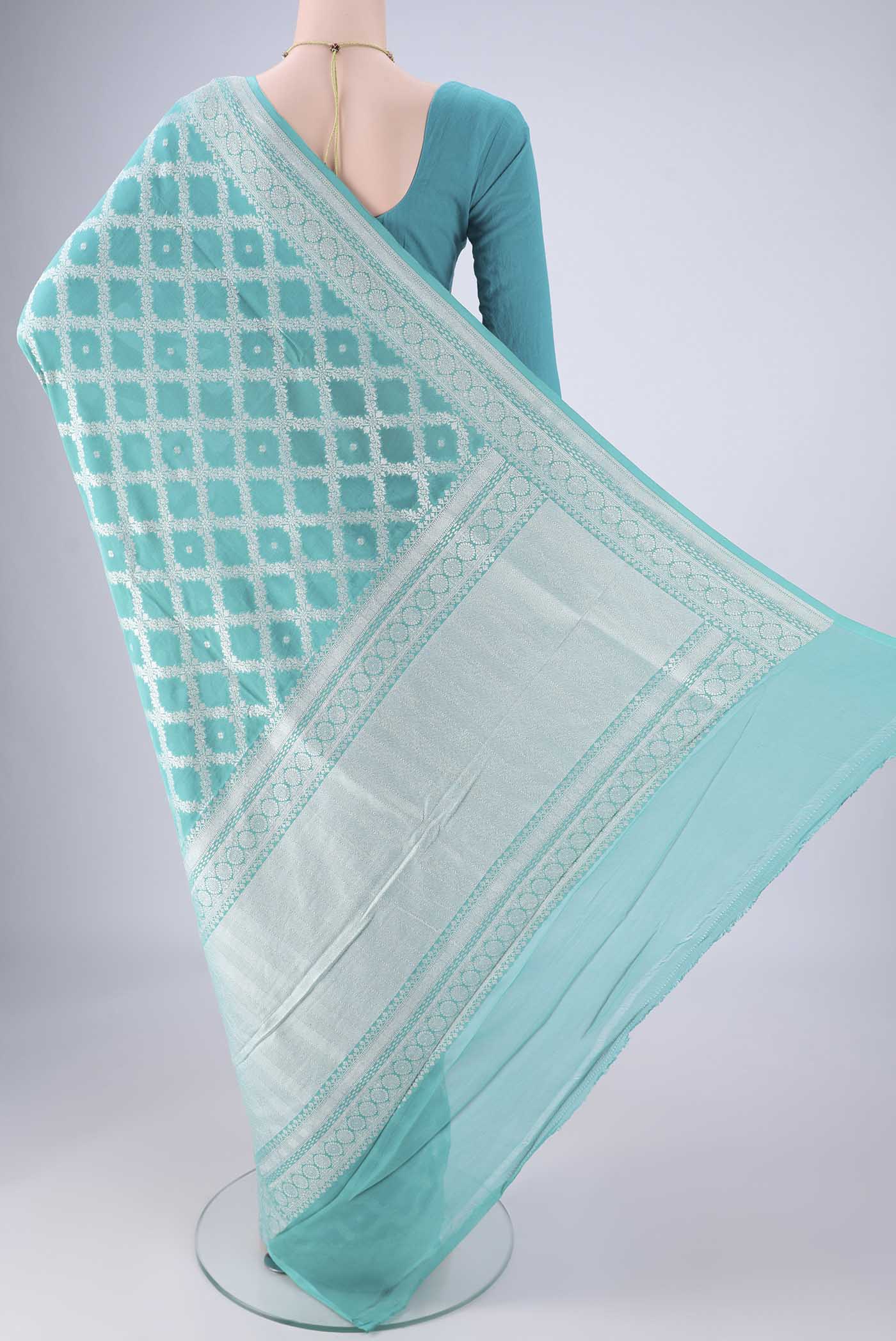 Flat view of Light Blue Banarasi Georgette Saree with Zari Brocade on the body and Zari Border. 
