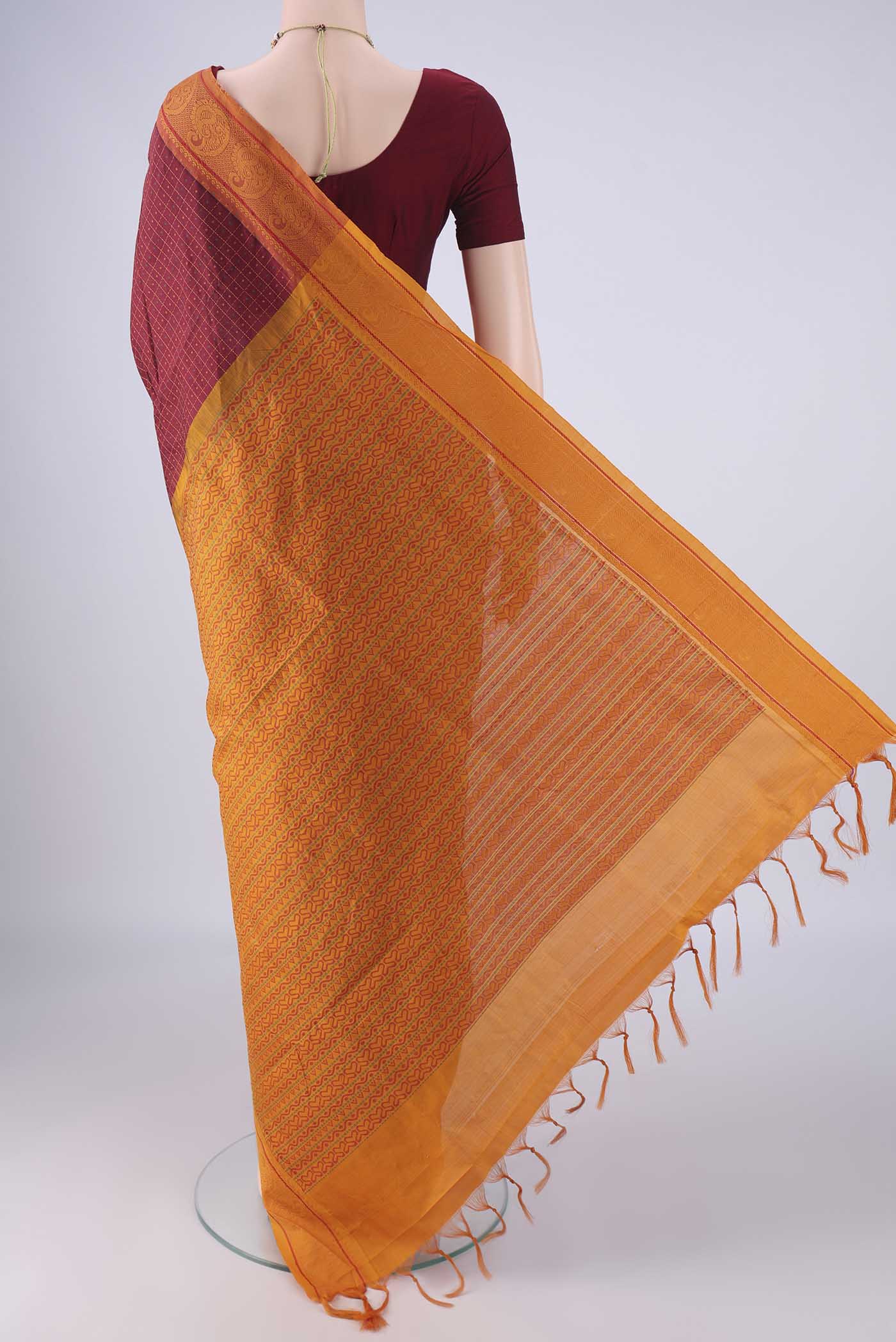 Flat view of Maroon Poly Cotton Saree with Checked design on the body and Thread Border. 