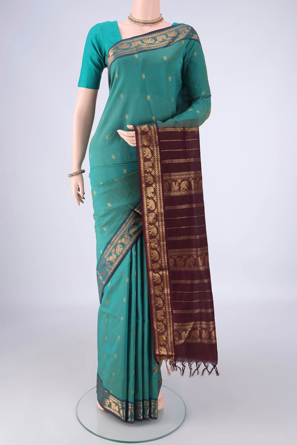 Green Blended Poly Cotton Saree with Zari Butta on the body and Zari Border.  displayed on a mannequin