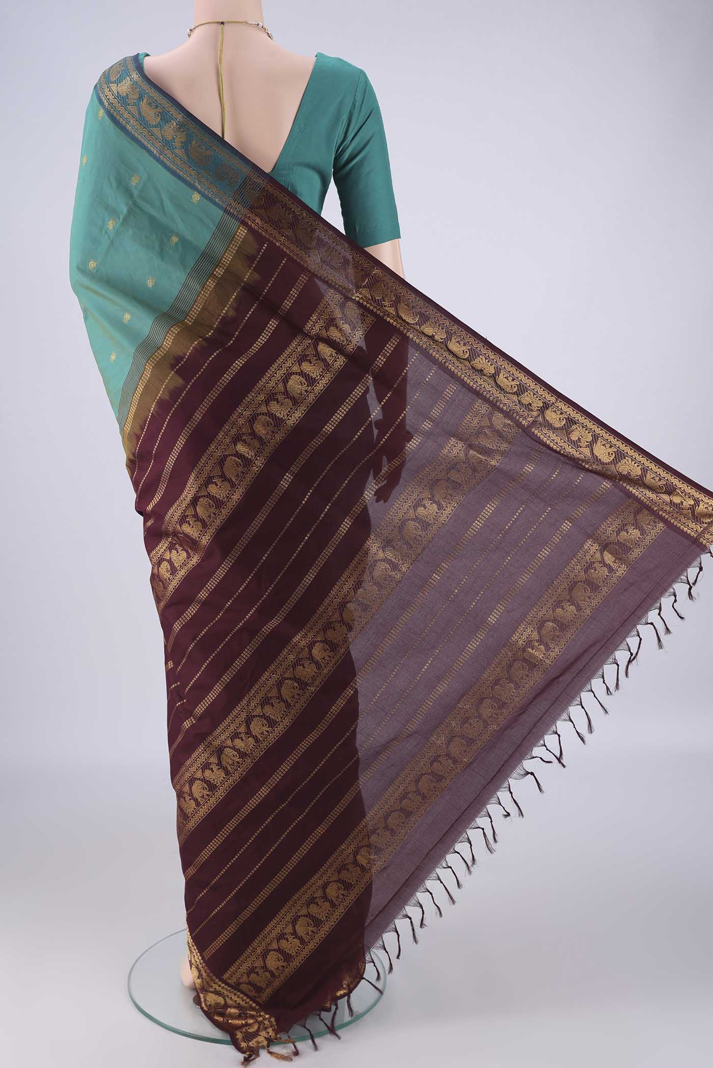 Flat view of Green Blended Poly Cotton Saree with Zari Butta on the body and Zari Border. 