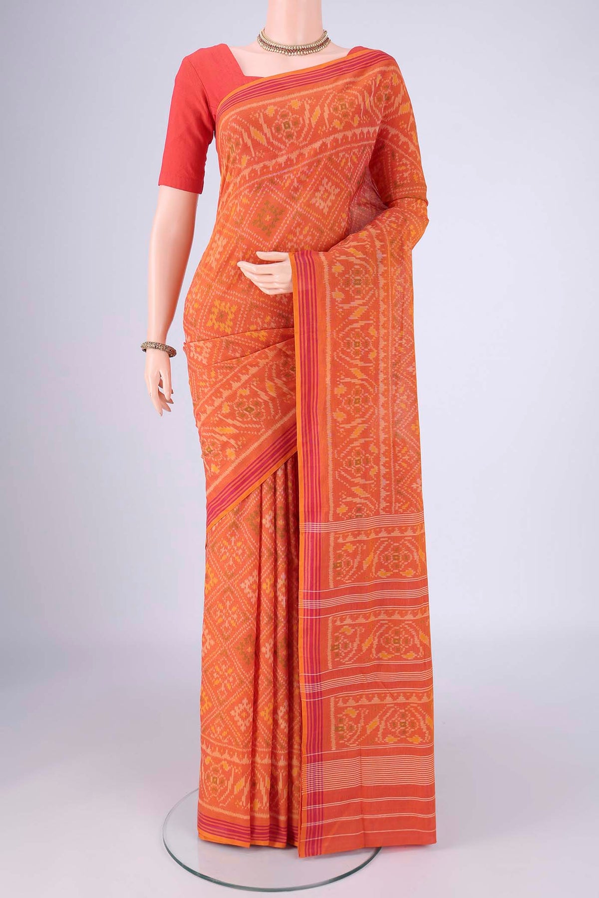 Brick Orange Pochampally Cotton Saree with Pure Ikat on the body and Ikat Border.  displayed on a mannequin