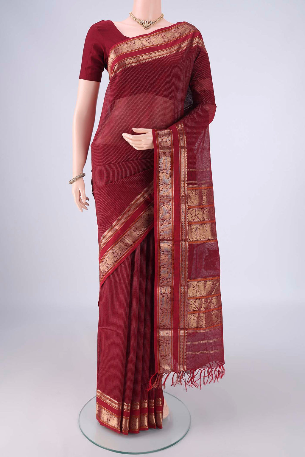 Maroon Kanchi Cotton Saree with Stripes on the body and Zari Border.  displayed on a mannequin
