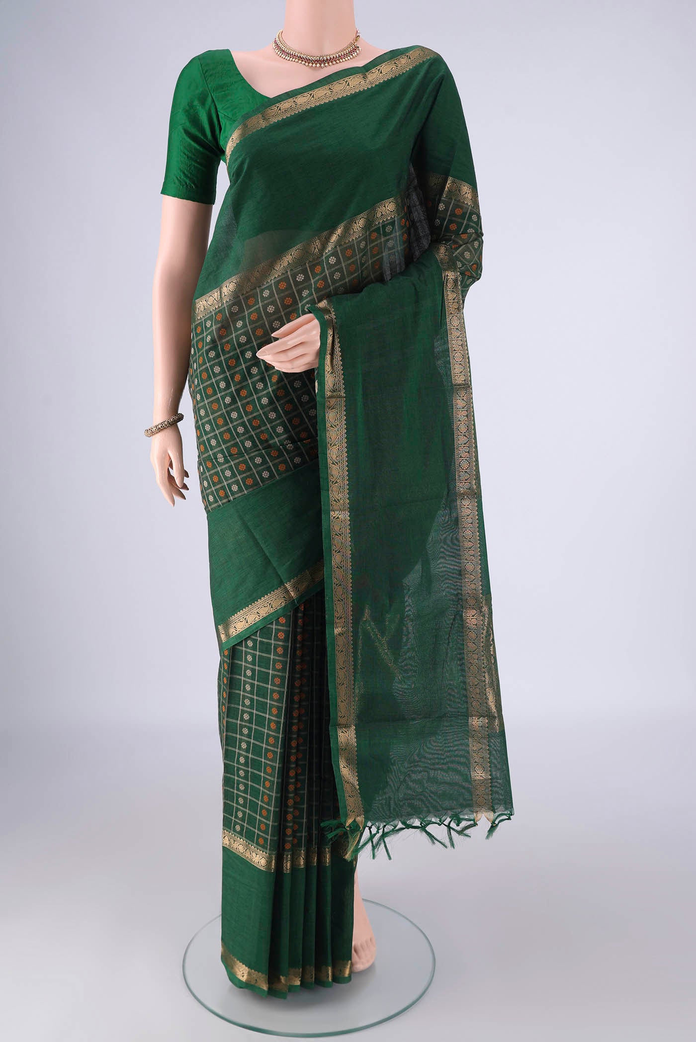 Bottle Green Kanchi Cotton Saree with Checked design on the body and Zari Border.  displayed on a mannequin
