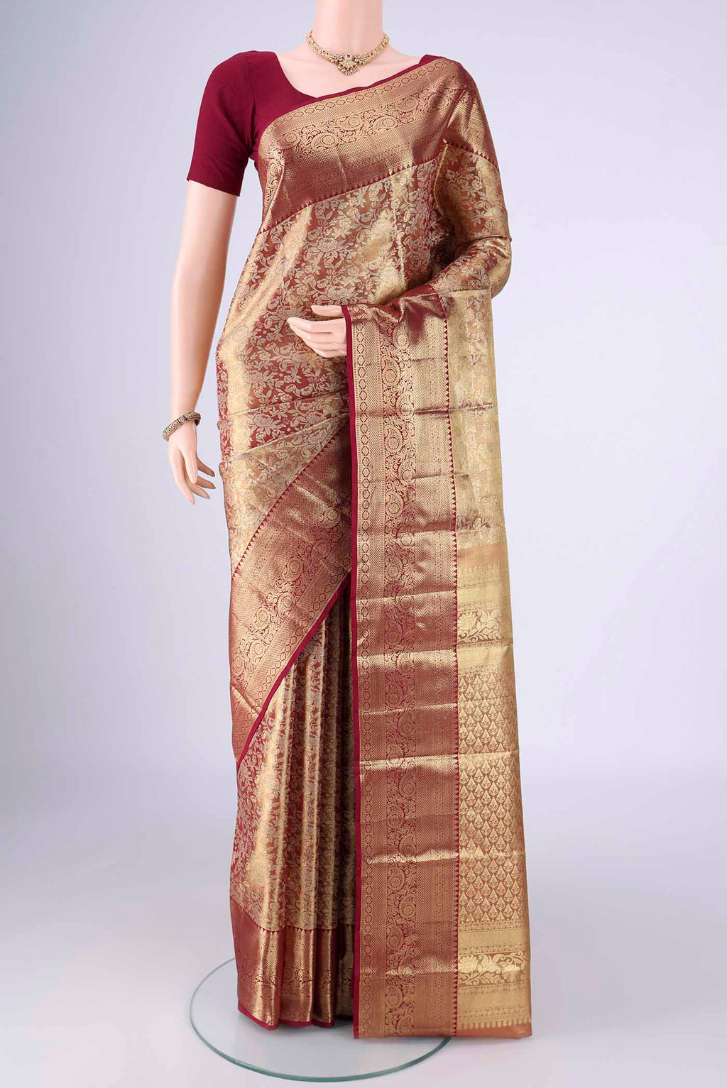 Gold with Red Dual Tone Kanjivaram Tissue Silk Saree with Zari Brocade on the body and Zari Border.  displayed on a mannequin