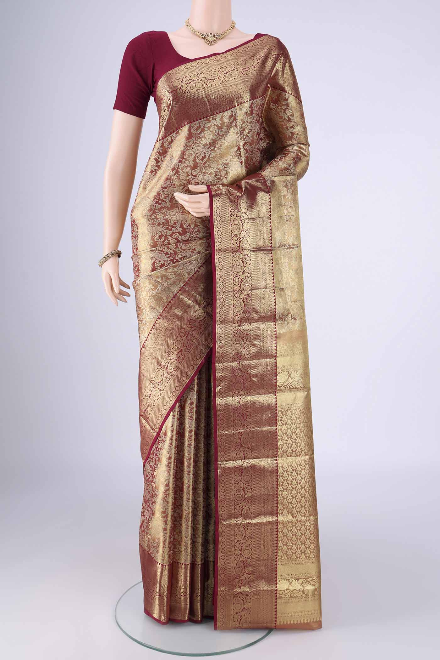 Gold with Red Dual Tone Kanjivaram Tissue Silk Saree with Zari Brocade on the body and Zari Border.  displayed on a mannequin