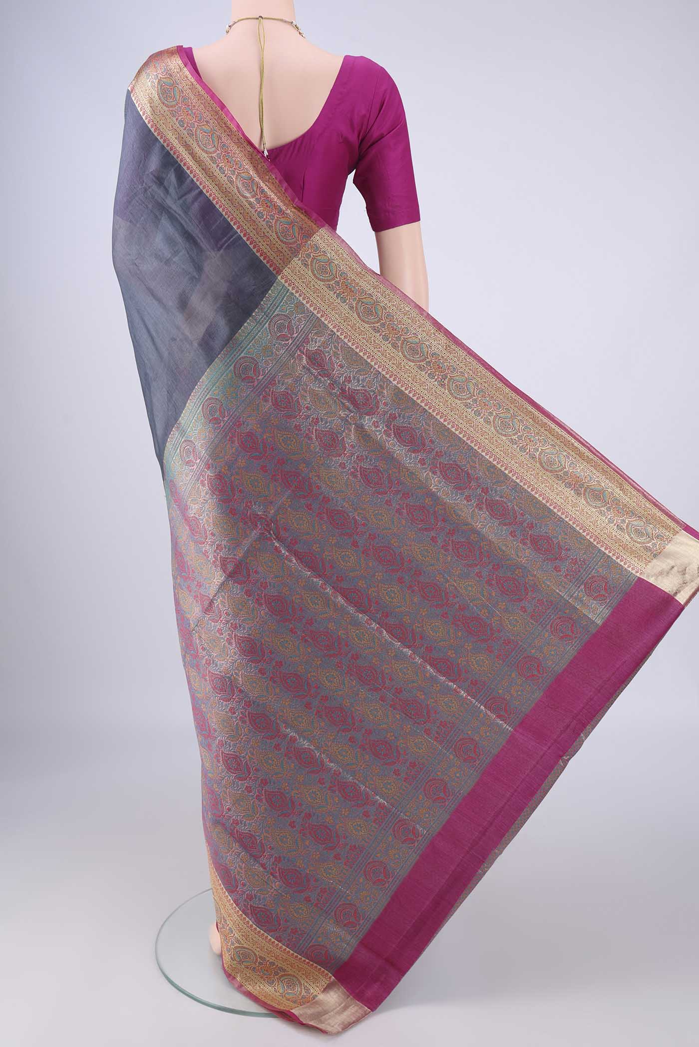 Flat view of Grey Banarasi Tussar Silk Saree with Plain Body and Zari Border. 