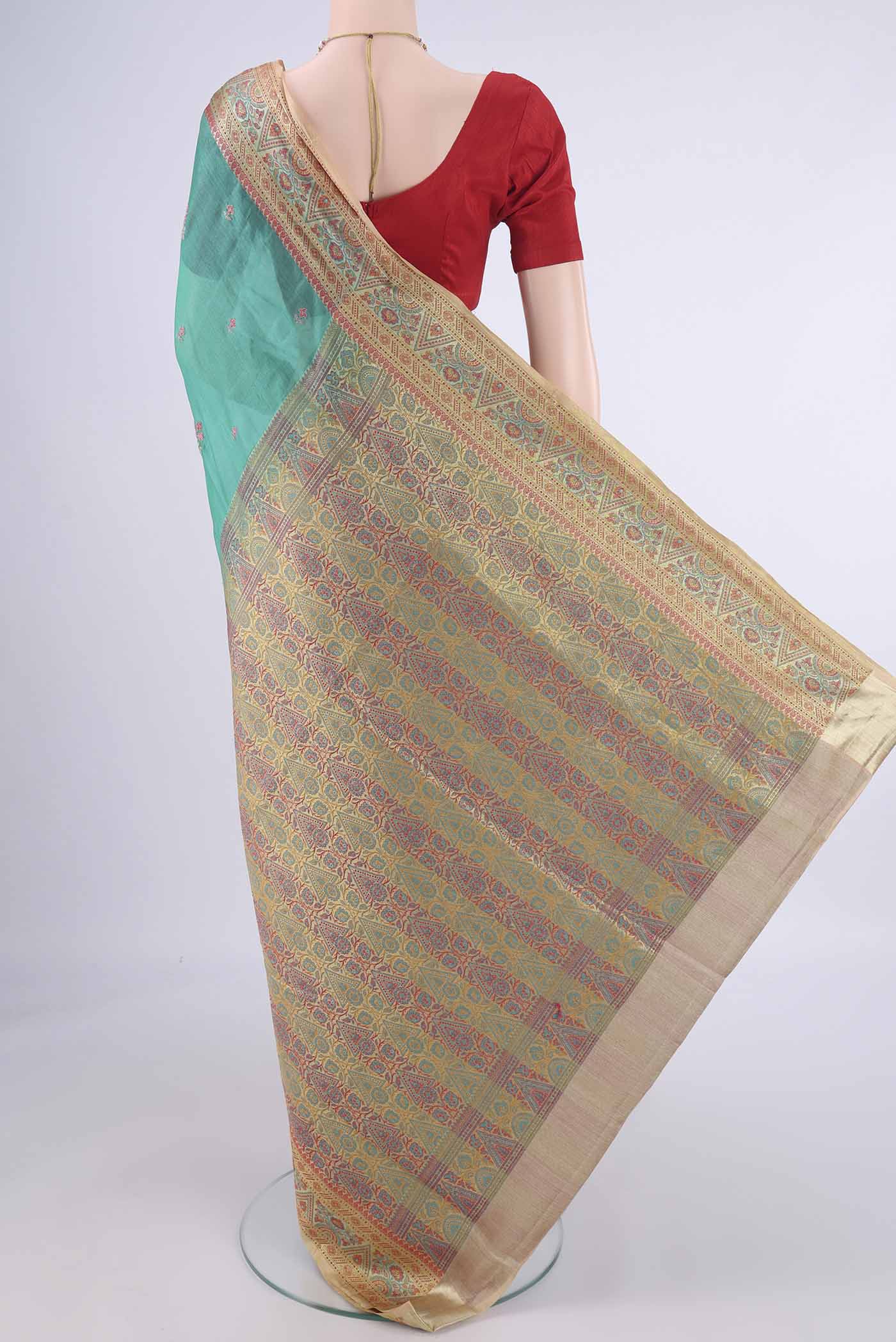 Flat view of Sea Green Banarasi Tussar Silk Saree with Embroidery on the body and Zari Border. 